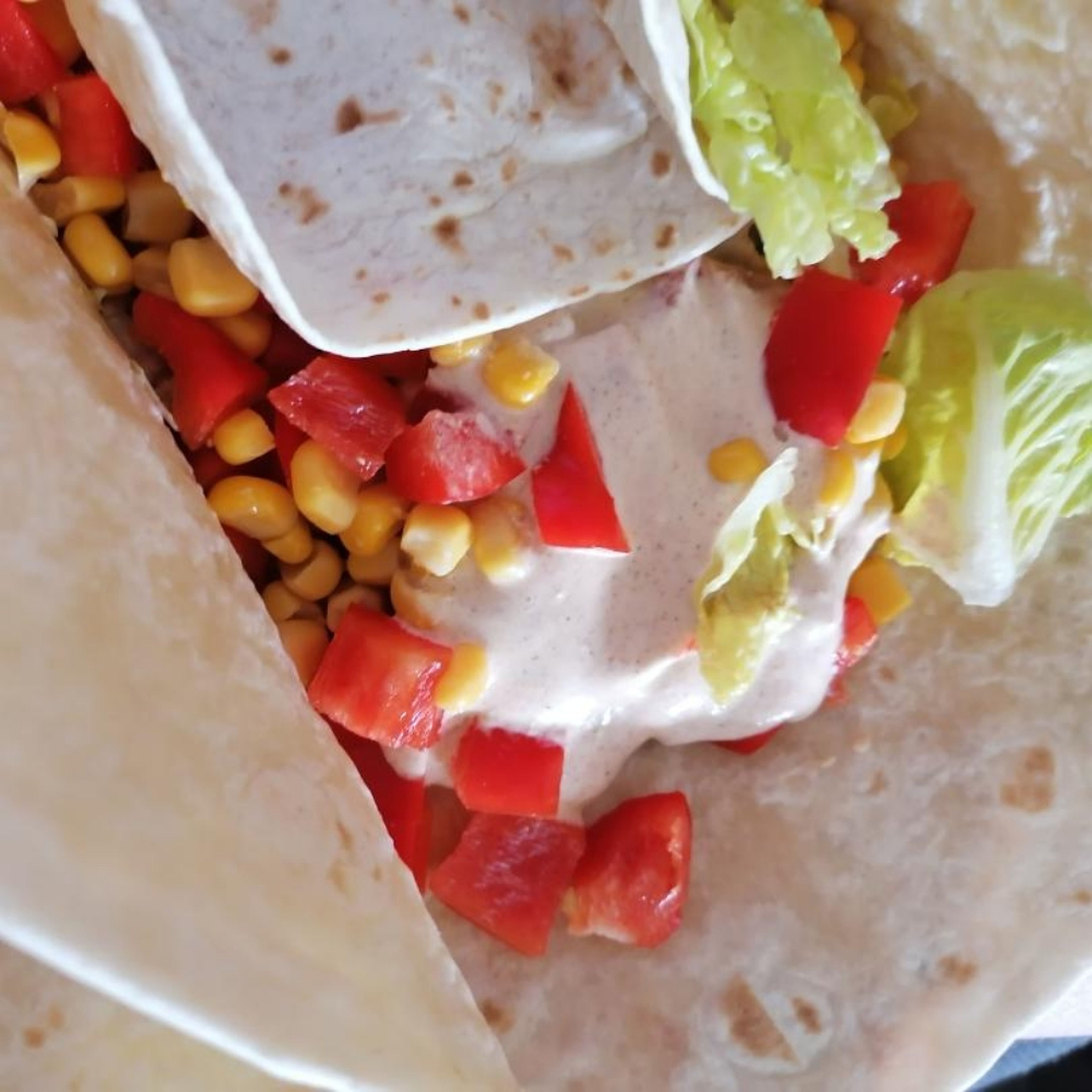 Danach die Wraps ausbreiten. Alle Lebensmittel draufgeben und mit dem Creme Fraîche verfeinern. Die Wraps dann zuklappen und genießen.