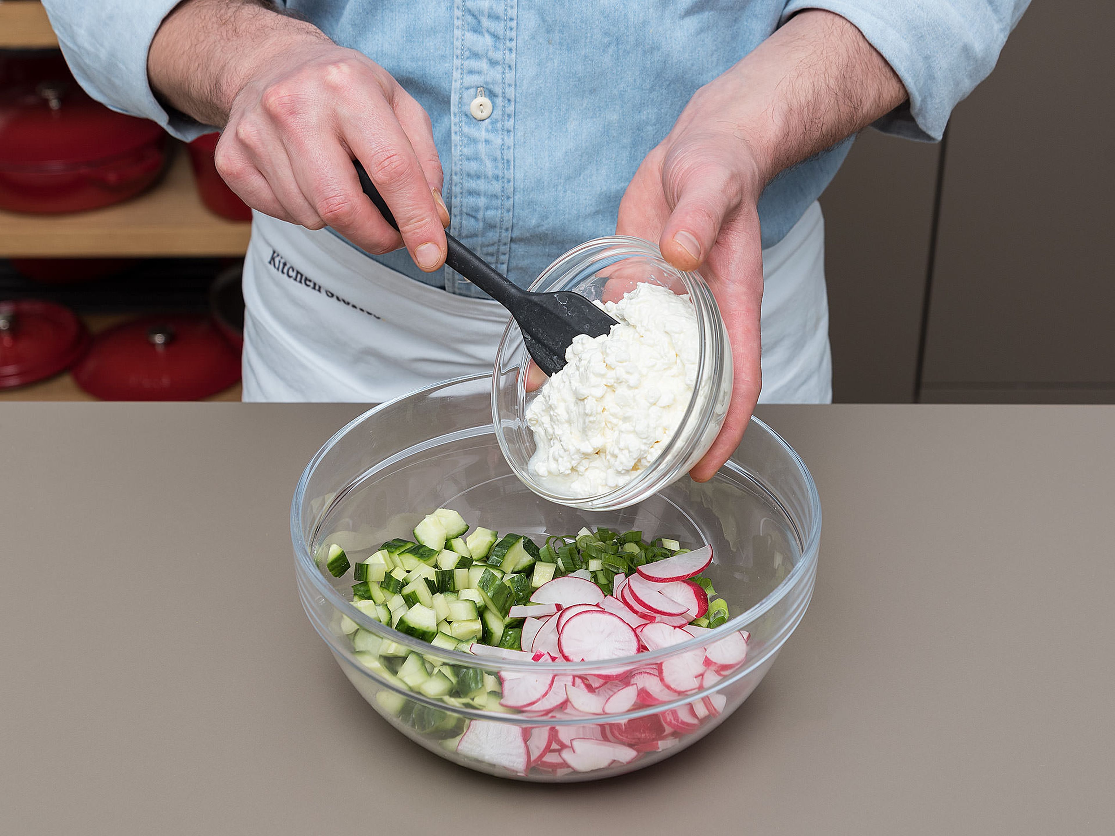 Peel and halve cucumber and scrape out the seeds with a spoon. Then, quarter the halves and cut them into small pieces. Clean radishes and green onions, then cut both into thin rings. In a bowl, mix the cucumber, green onions, and radish with cottage cheese. Season to taste with salt and pepper.