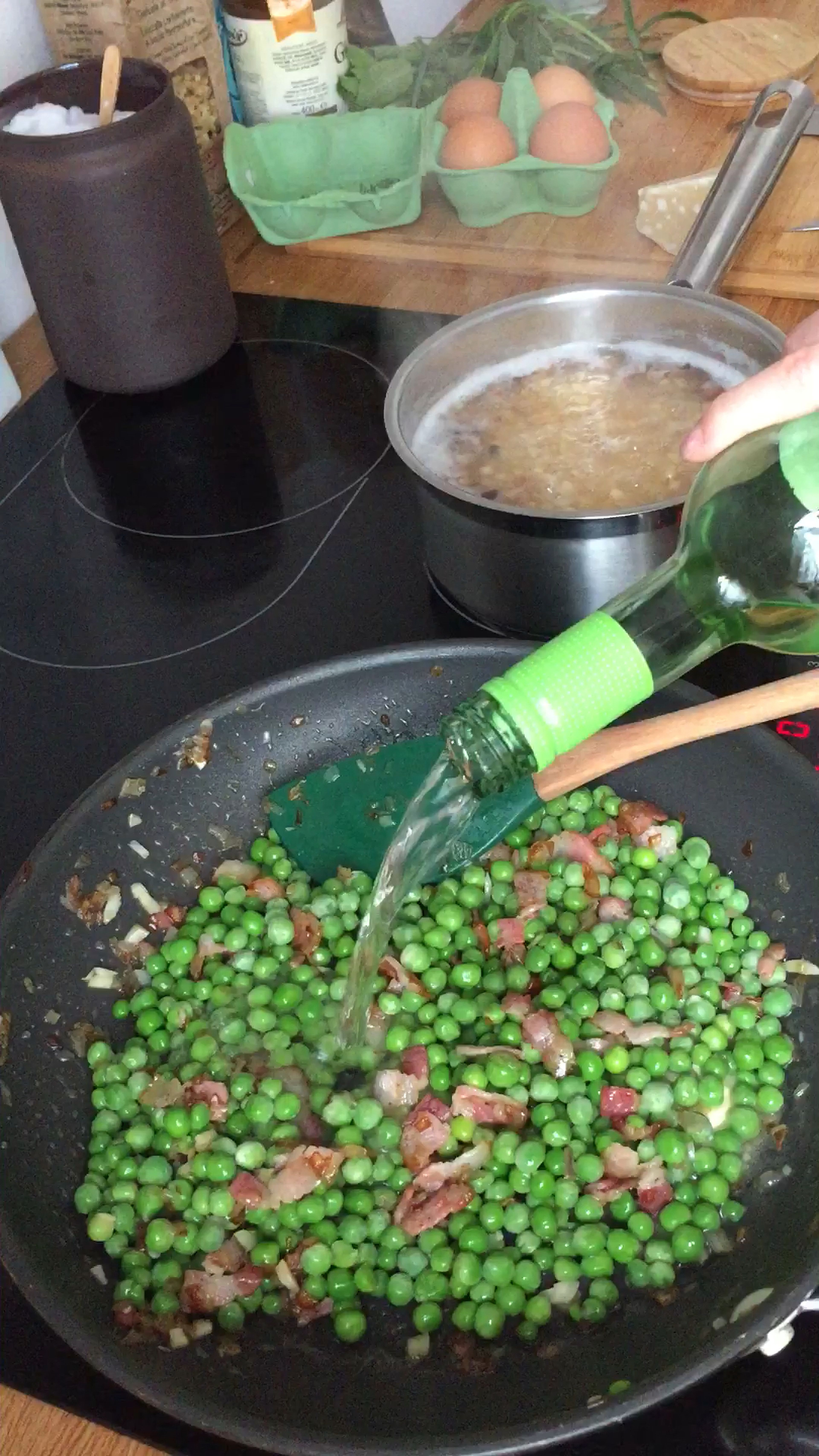 Erbsen zum Speck geben und kurz mit anbraten. Mit Weißwein ablöschen und dann mit Hühnerbrühe auffüllen und etwas einkochen lassen.
