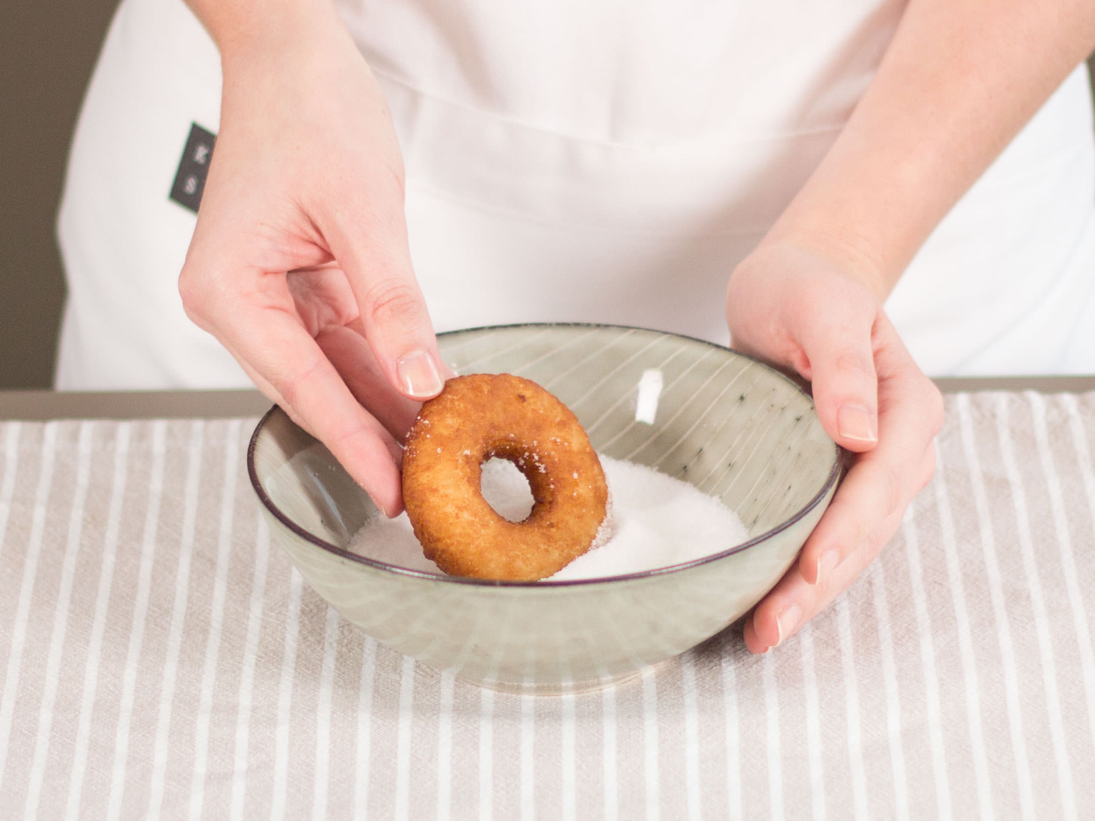 Pour sugar into a small bowl. Roll bombolini in sugar and transfer to a plate for serving. Enjoy!