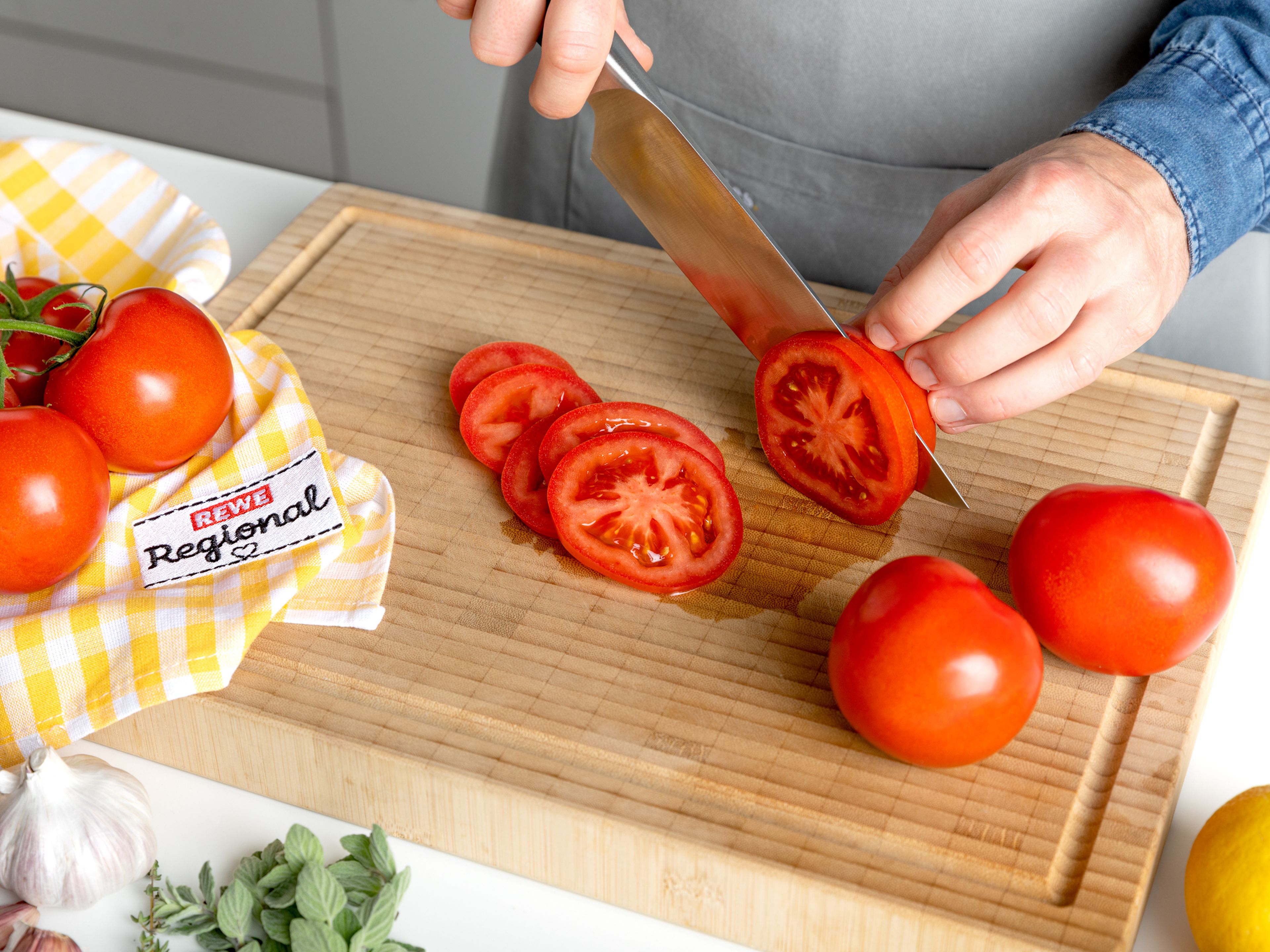 Backofen auf190°C vorheizen. Schalotte und Knoblauch schälen und in dünne Scheiben schneiden. Tomaten ebenfalls in Scheiben schneiden. Thymian- und Oreganoblätter grob hacken.