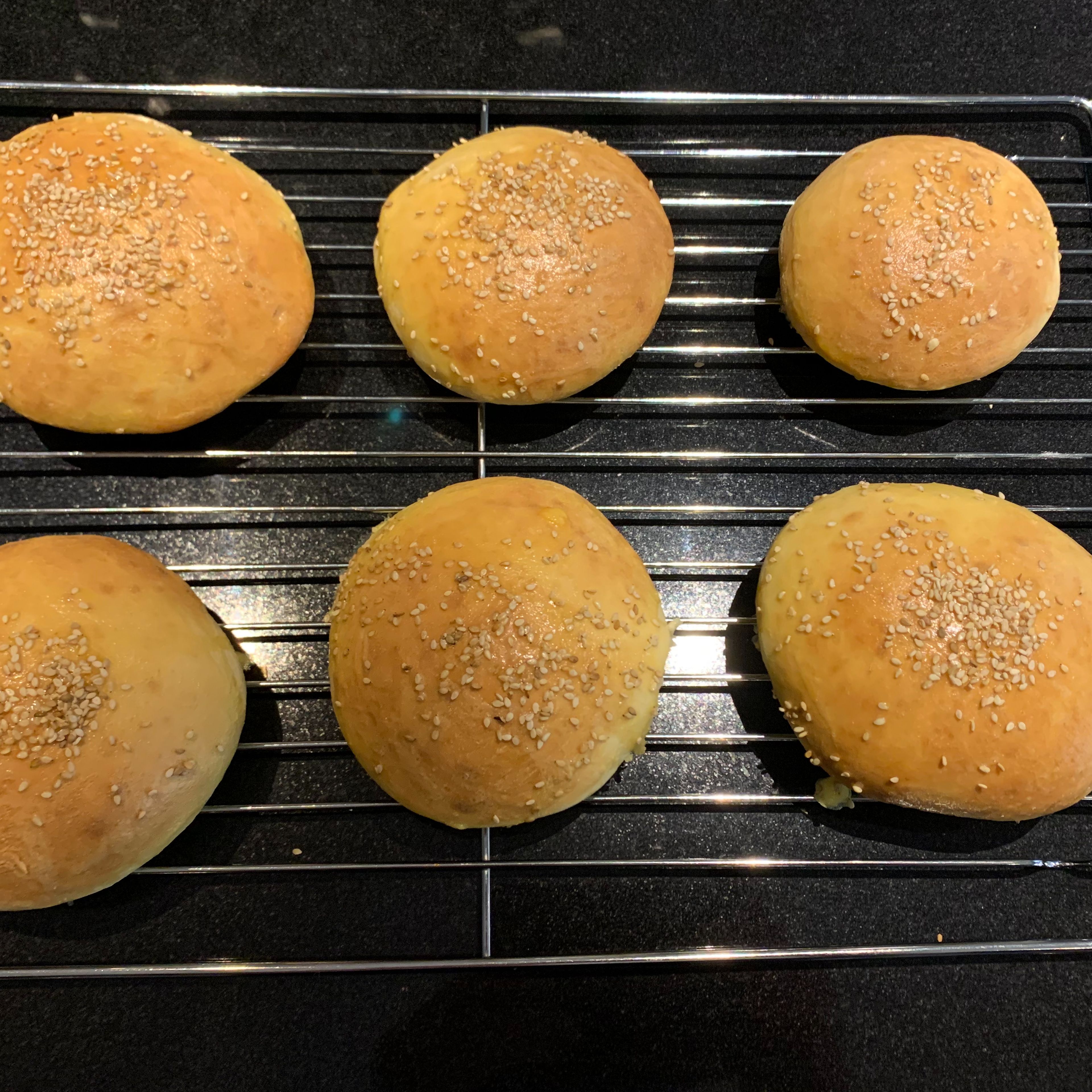 Das beiseitegelegte Ei schlagen und damit die Buns bestreichen. Nun kommen sie für 10 Minuten bei 220°C (Umluft/Heißluft) oder bis sie Gold-Braun sind auf der mittleren Schiene in den Backofen. Wenn Sie Sesamsamen auf den Buns möchten, nehmen sie die Brötchen nach ca 8 Minuten kurz aus dem Backofen, bestreichen Sie diese erneut mit dem geschlagenem Ei und bestreuen sie die Buns mit Sesamsamen.