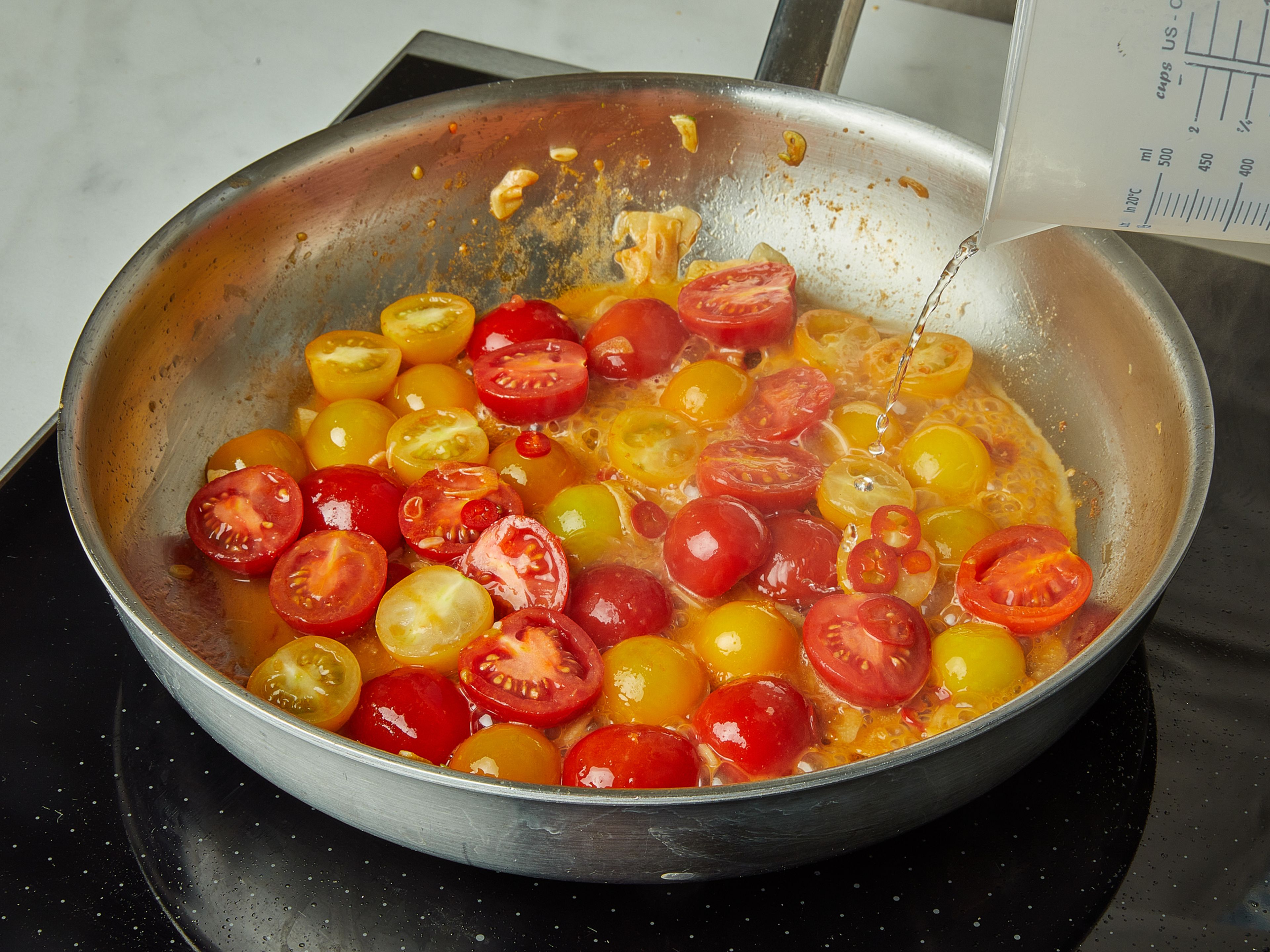 In the same pan heat the remaining olive oil. Add garlic, chili, and tomatoes and sauté together for approx. 2 min. Then deglaze with white wine.  Let simmer for approx. 2 min. until the wine has almost boiled away. Season everything with a generous pinch of salt and pepper.