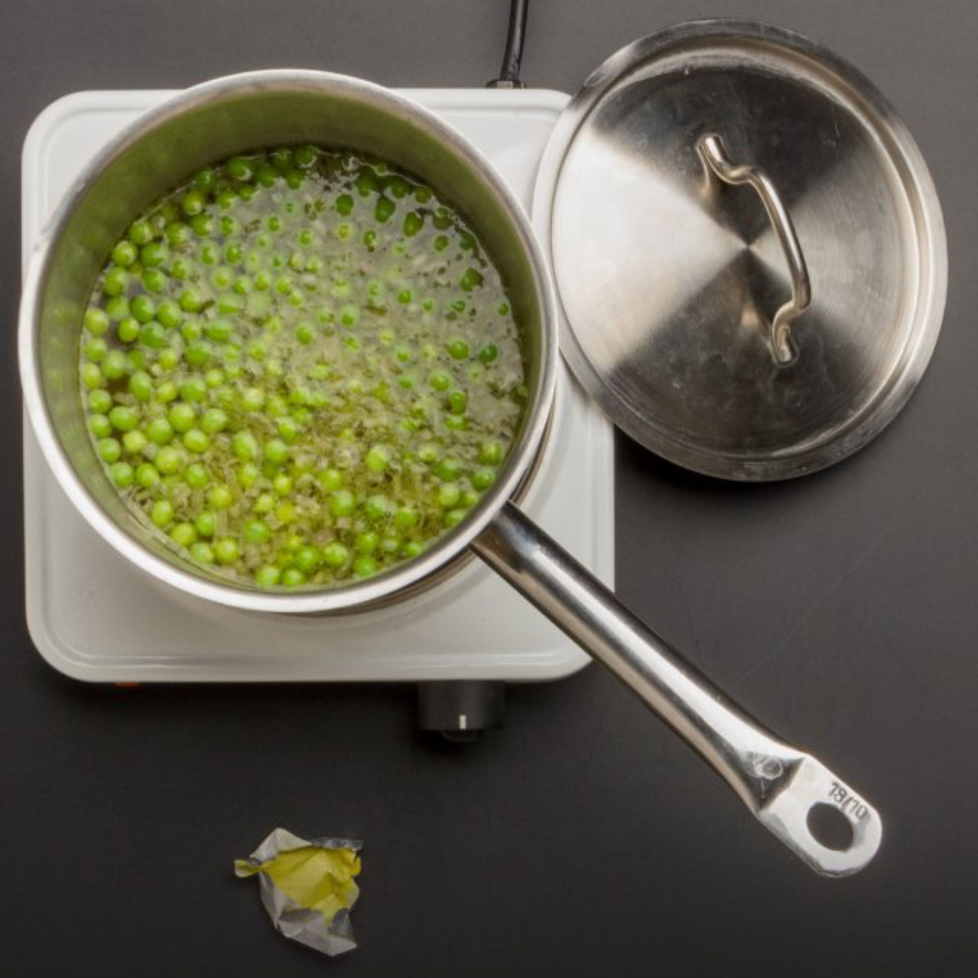 Add water and the bouillon to the saucepan, bring to boil and simmer for about 5 minutes at low to medium temperature. Add peas and simmer for about 10 minutes.