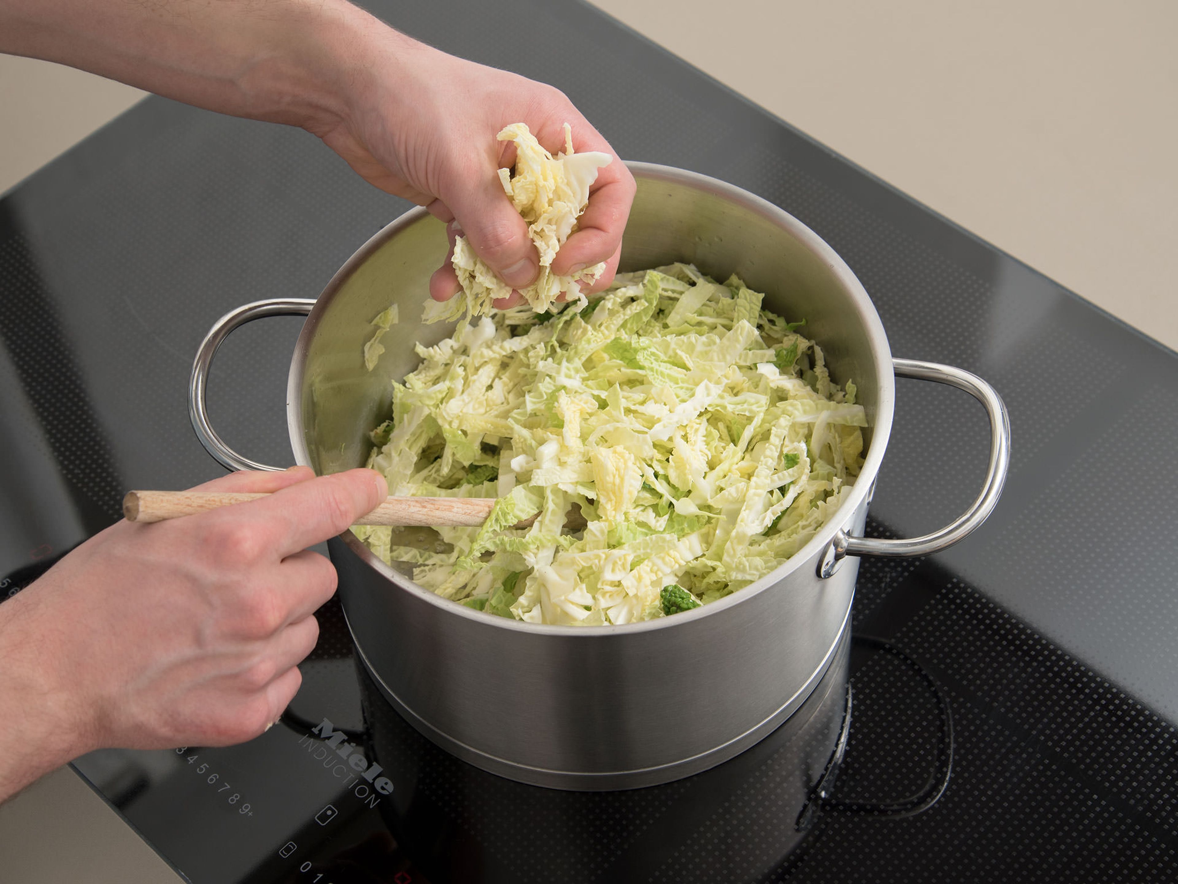 Sauté garlic with some oil in a large pot. Add cabbage, season with salt and pepper, and cook for approx. 10 min.