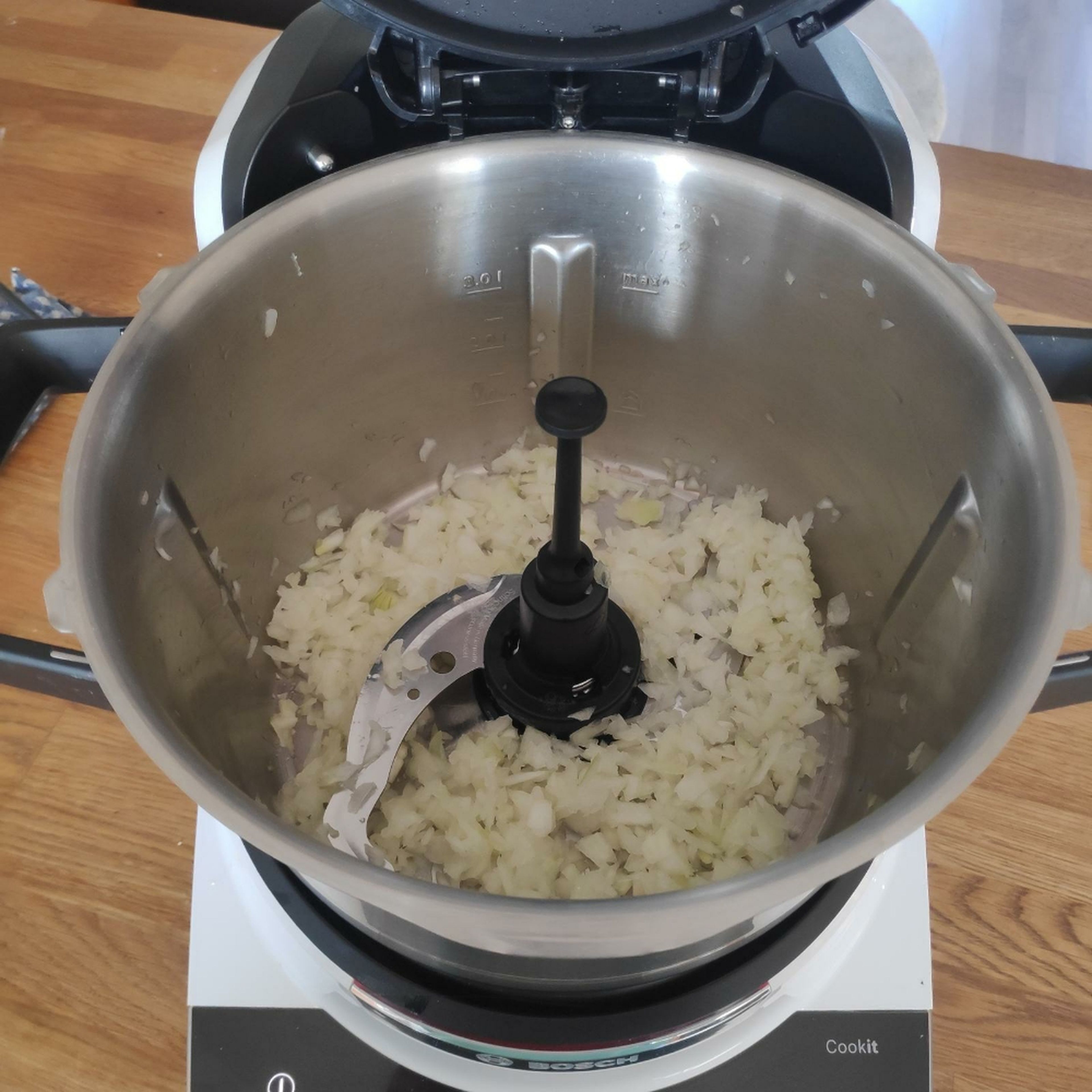Zwiebel schälen, vierteln und im Cookit bei geschlossenem Deckel und eingesetztem Messbecher zerkleinern (Universalmesser I Stufe 14 I 10 Sek.). Universalmesser entfernen und 3D-Rührer einsetzen. Öl hinzugeben und bei geschlossenem Deckel ohne Messbecher andünsten (3D-Rührer I Stufe 2 I 3 Min. I 140°C).