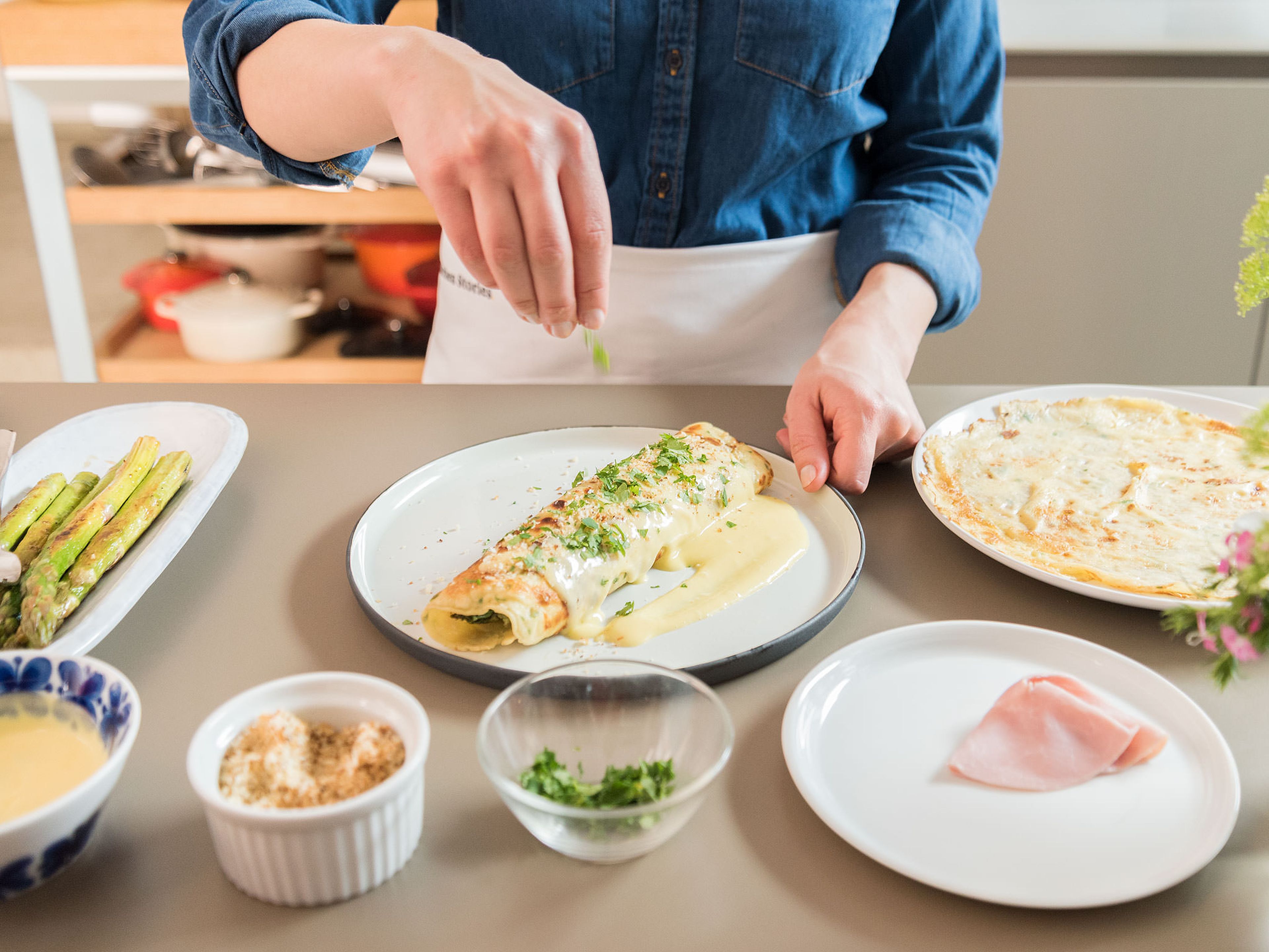 Transfer crêpe to a serving plate. Place two slices of ham and four green asparagus shoots on each crêpe, then roll carefully. Drizzle eggnog hollandaise on top, sprinkle with toasted panko, and garnish with fresh parsley. Enjoy!