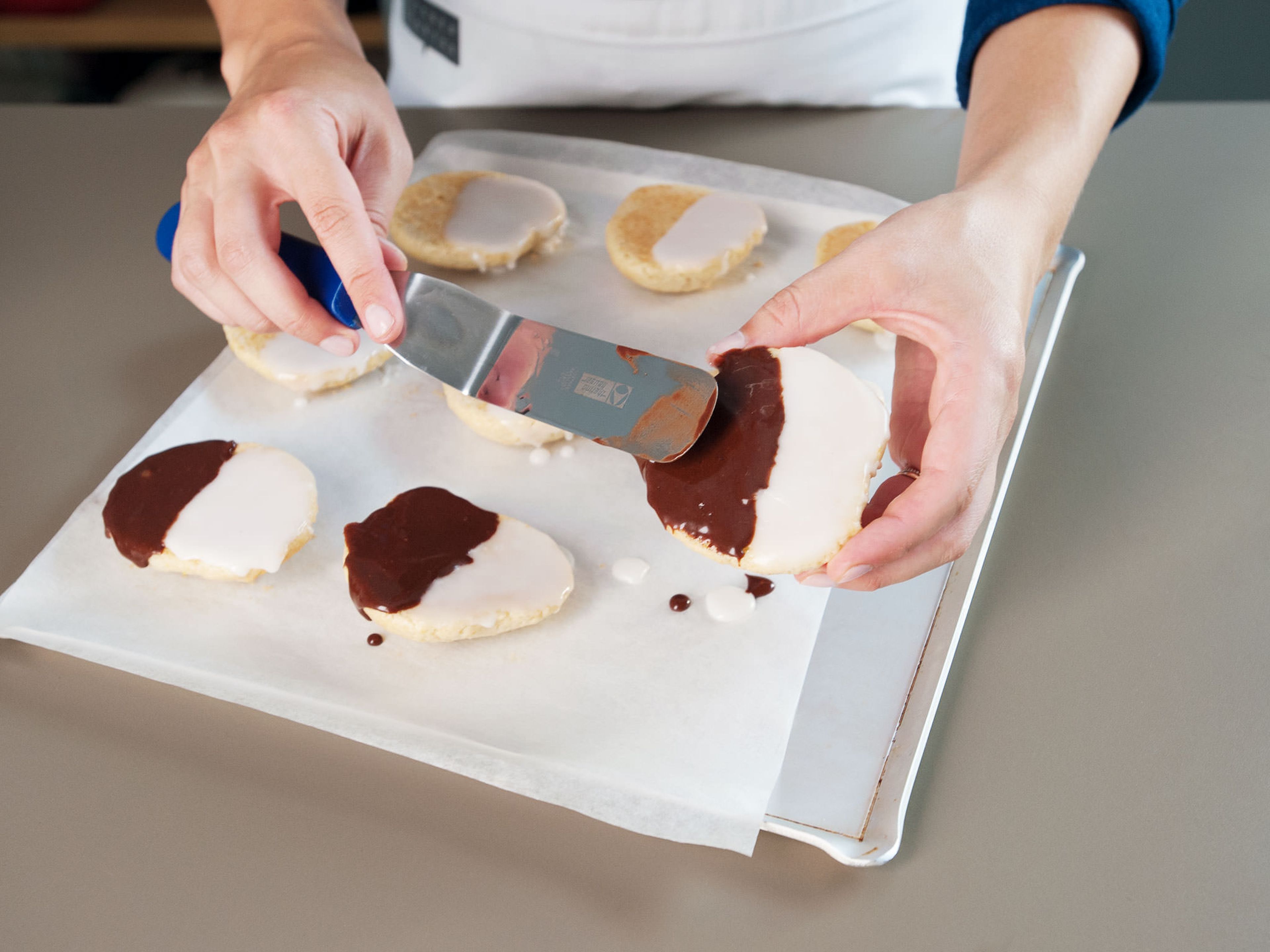Spread white icing over half of the flat side of each cookie with an offset spatula, then, set aside until icing firms up. Frost the second half with chocolate icing. Enjoy!
