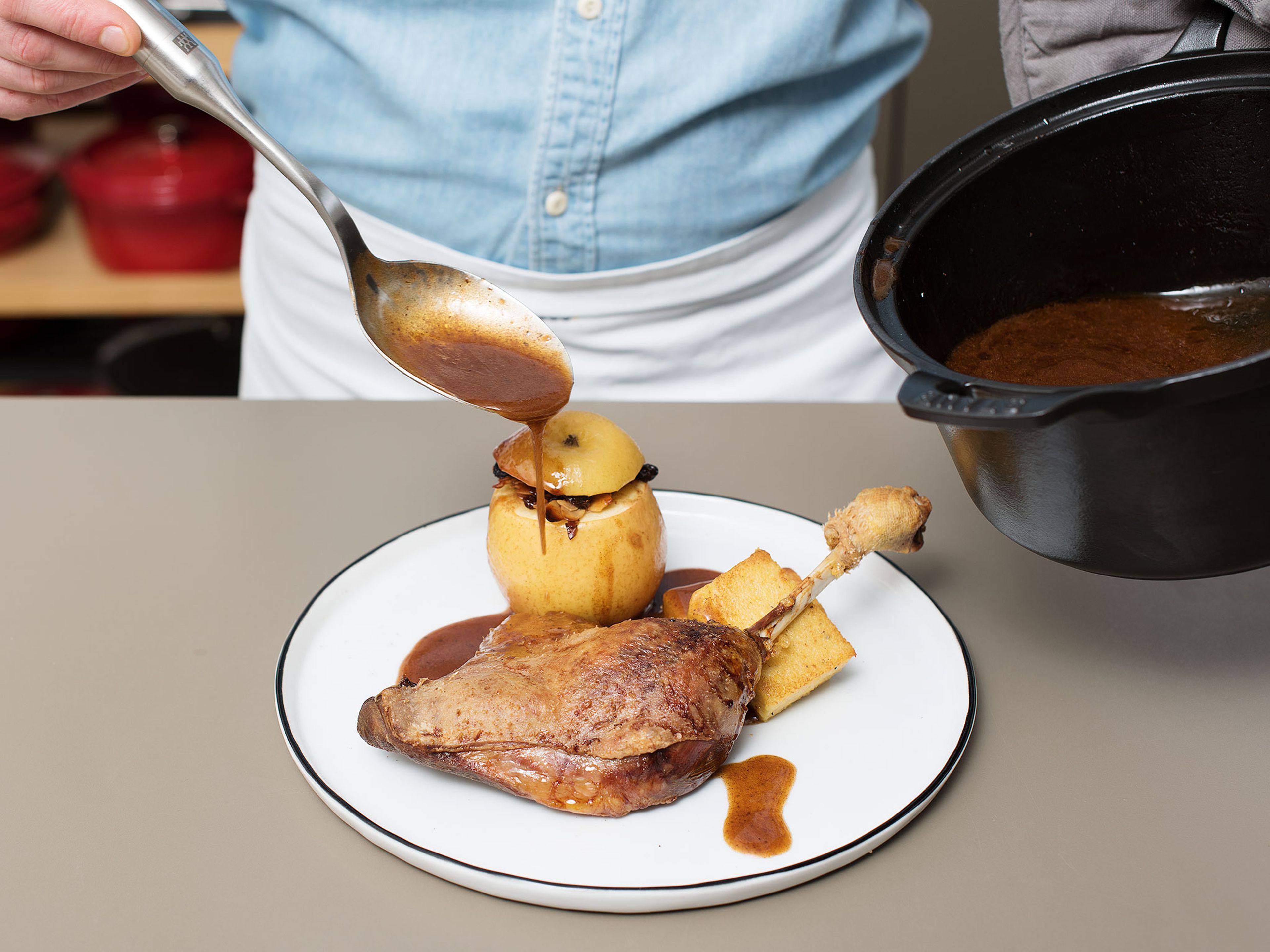 Polentastücke, Bratapfel und Gänsekeule auf einem Teller anrichten und Soße darüber geben. Guten Appetit!