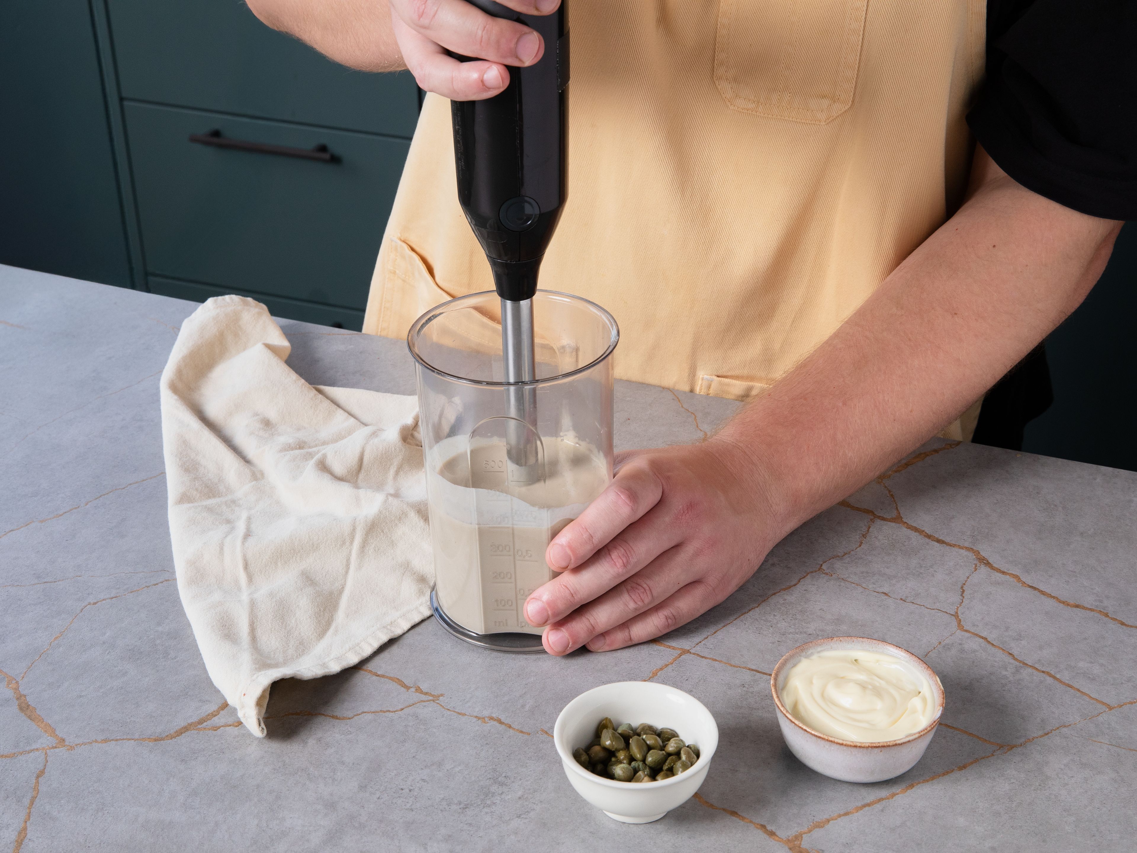 Mayonnaise, Thunfisch mit Öl, Sardellenfilets, Kapern, Zitronensaft und etwas von dem Kapernsud in einen Mixer geben und pürieren, bis eine glatte Sauce entsteht.