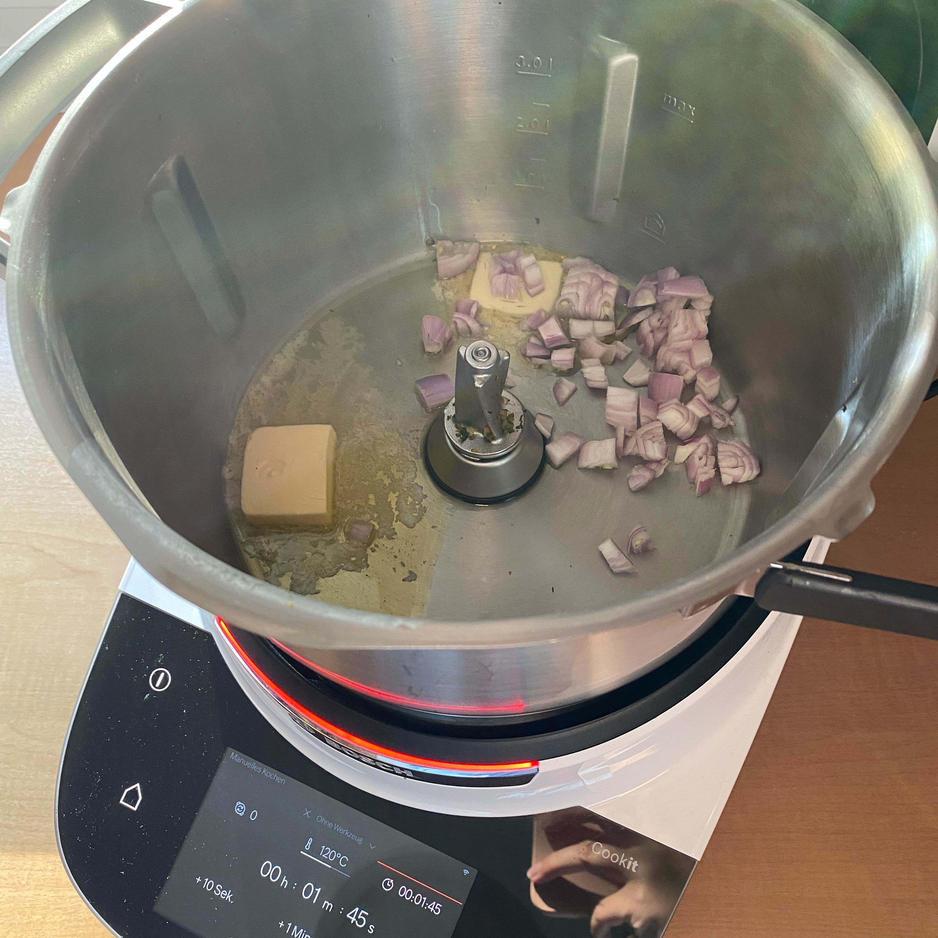 Schalotte hacken und mit Butter in den Mixtopf geben. Ohne Werkzeug für 2 Minuten bei 120°C anschwitzen. Mit dem Cookit Spatel umrühren.