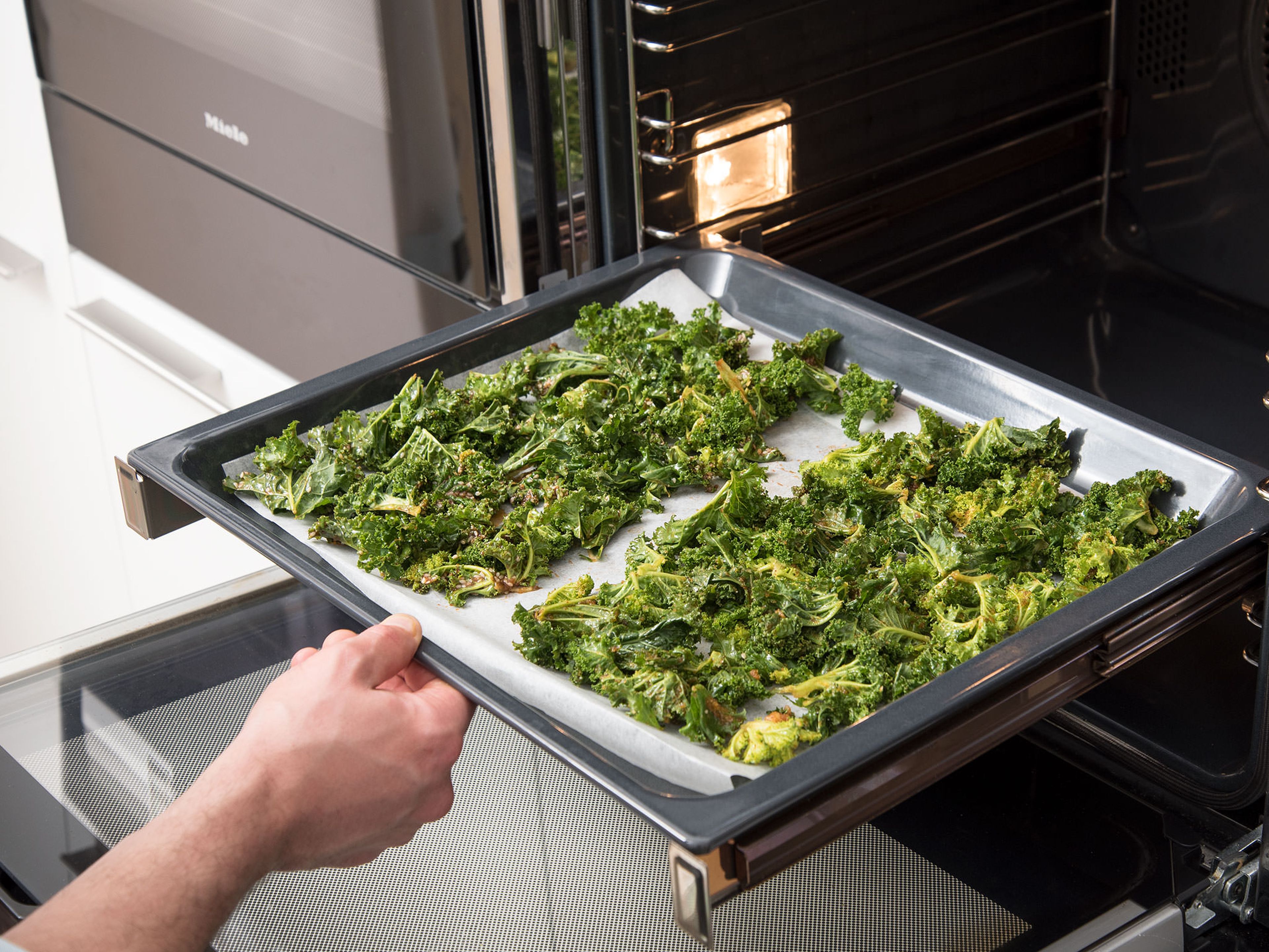 Spread the kale evenly on a parchment-lined baking sheet in one layer. Bake at 100°C/200°F for approx. 30 min. or until kale is crispy and slightly brown. Remove from oven and allow to cool completely. Enjoy!