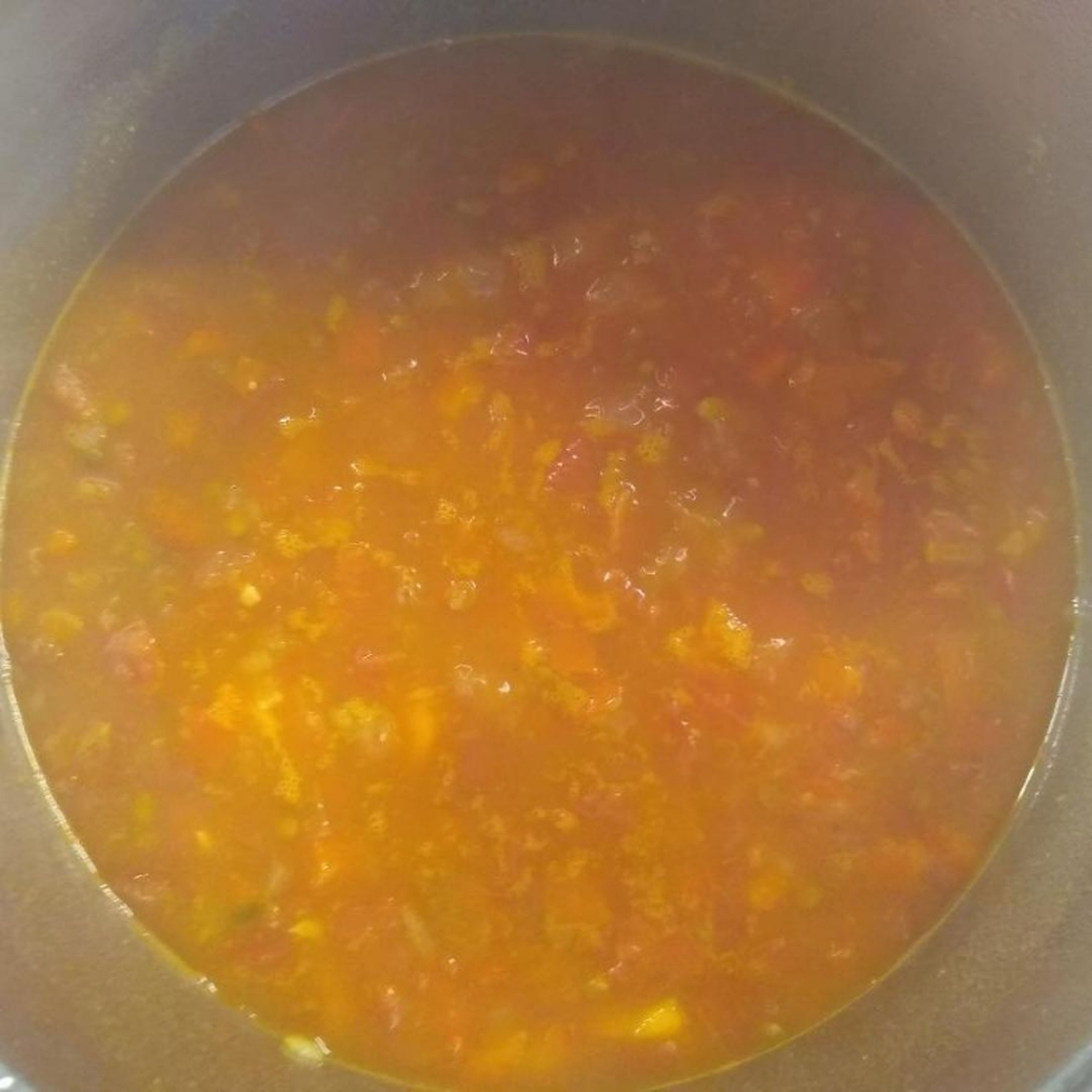 Die Dosentomaten und die Brühe drübergießen. Mit Kreuzkümmel, Currypulver, Koriander, Salz und Pfeffer würzen und aufkochen lassen. 15min bei geschlossenem Deckel köcheln lassen.