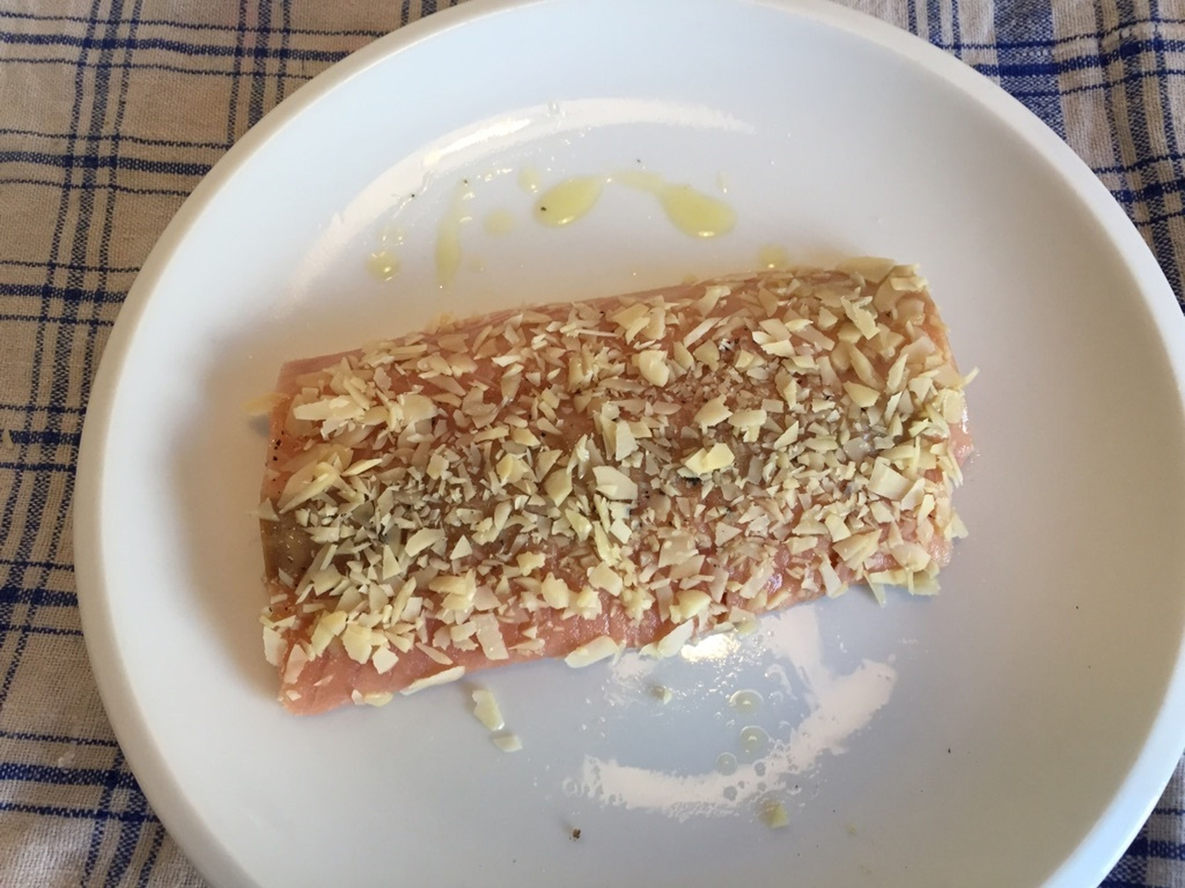 Roll fish in almonds and press gently to seal. Preheat a small frying pan over medium heat and coat with the remaining olive oil.