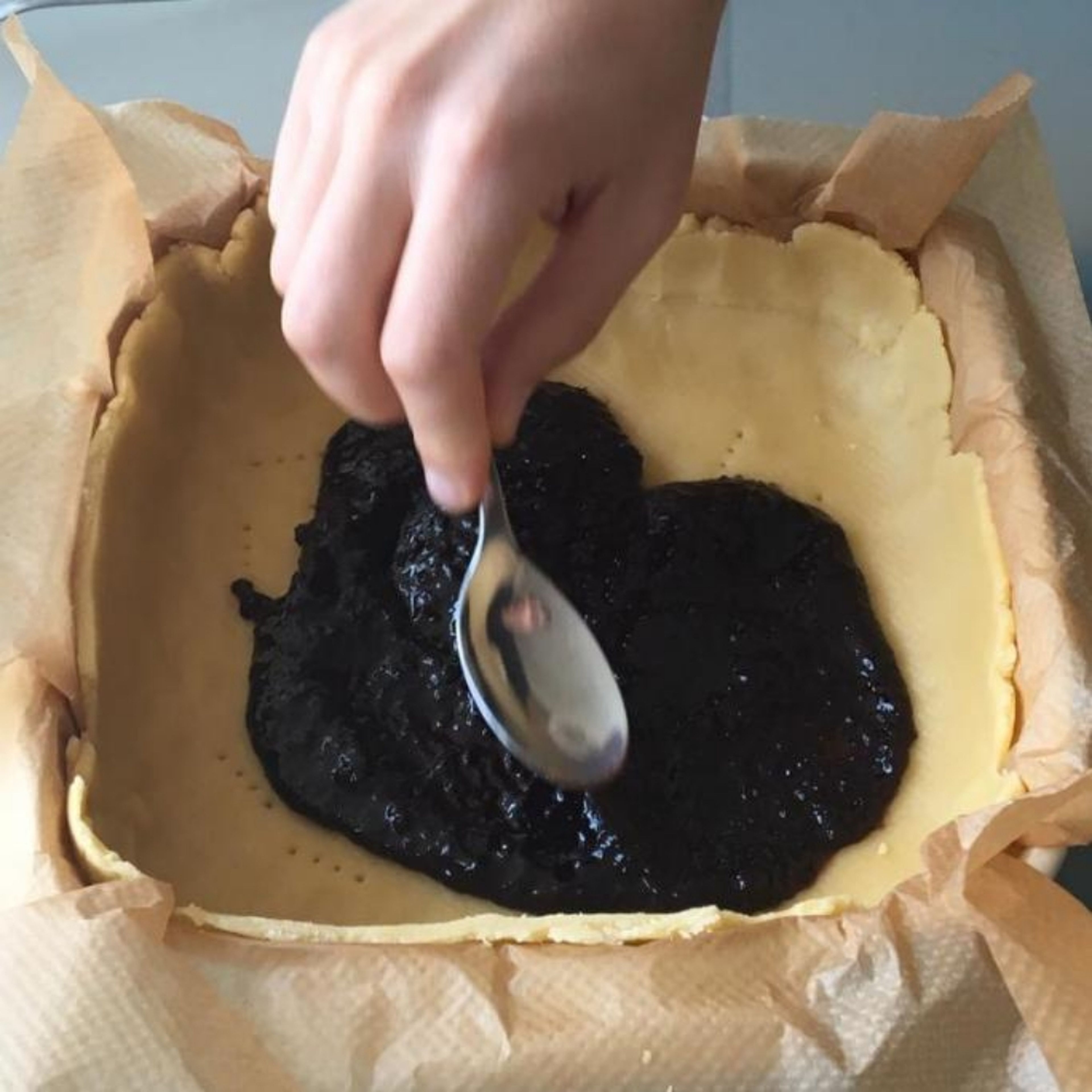 Spread uniformly the jam on the dough.