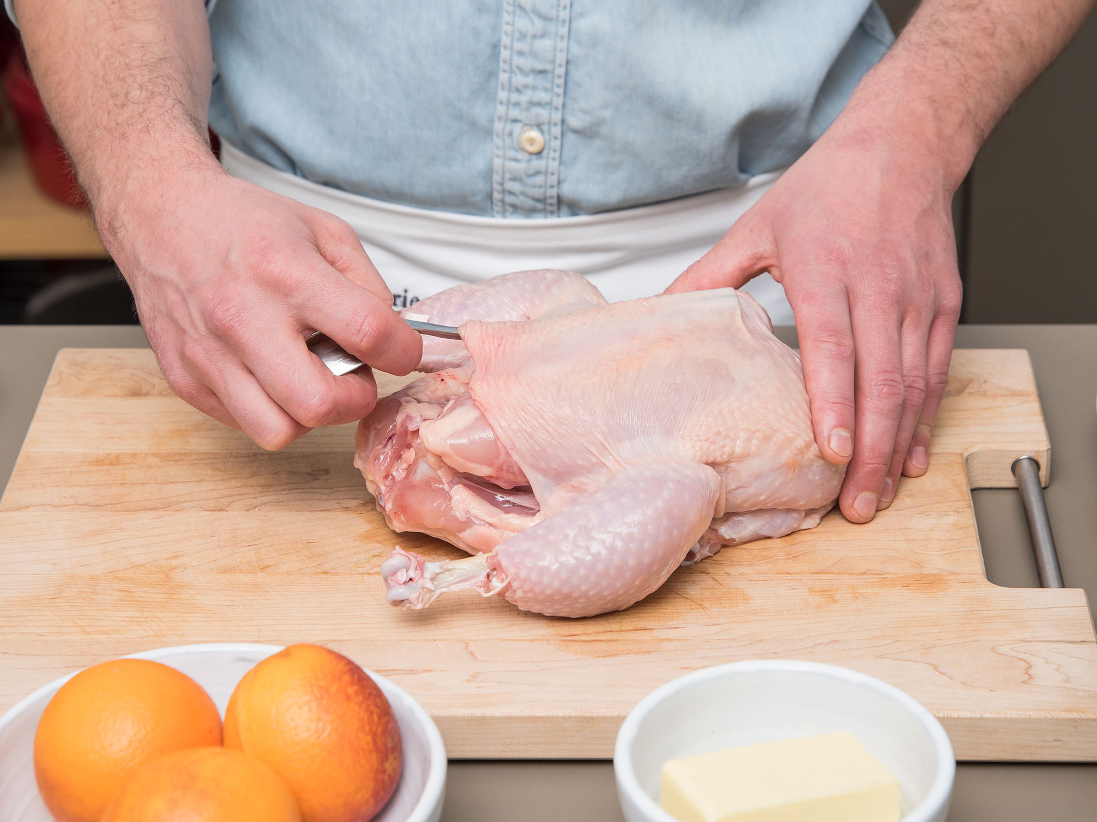 Backofen auf 180°C vorheizen. Mit dem Stiel eines Löffels von der Brustseite beginnend vorsichtig unter die Haut des Hähnchens fahren um diese vom Fleisch zu lösen. Die Haut sollte dabei intakt bleiben. Das Hähnchen anschließend beiseitelegen.