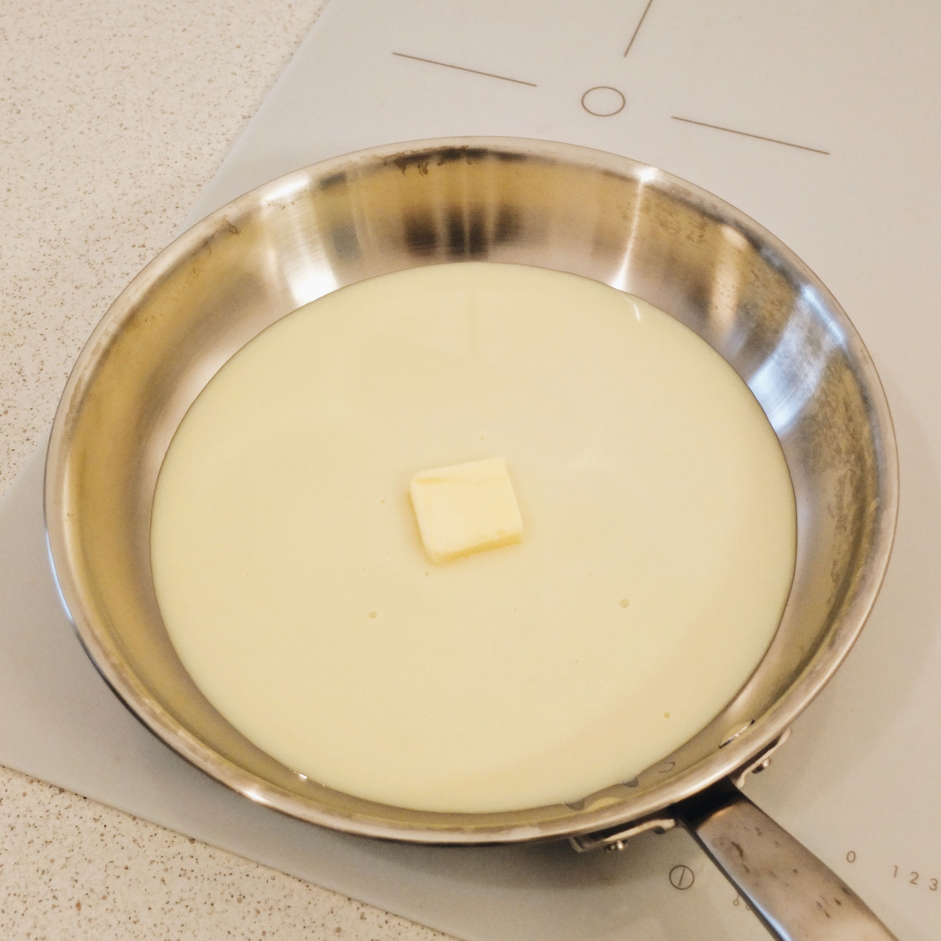 Mix the condensed milk and butter together in a pan and cook it over low-medium heat, stirring constantly until it has thickened and the mixture is sticking slightly to the bottom of the pan.