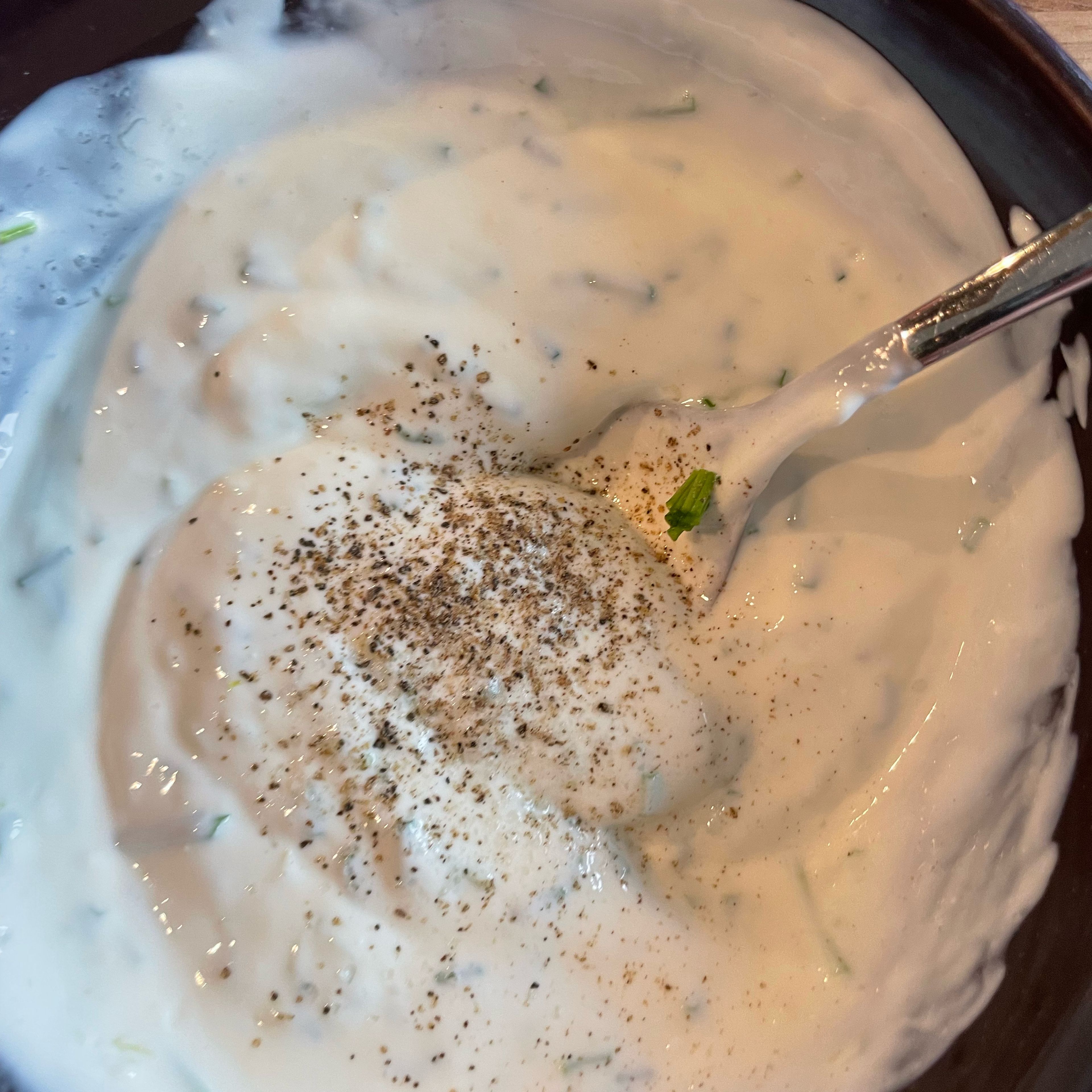Joghurt mit Schnittlauch, Zitronensaft und Abrieb mischen und mit Salz und Pfeffer würzen