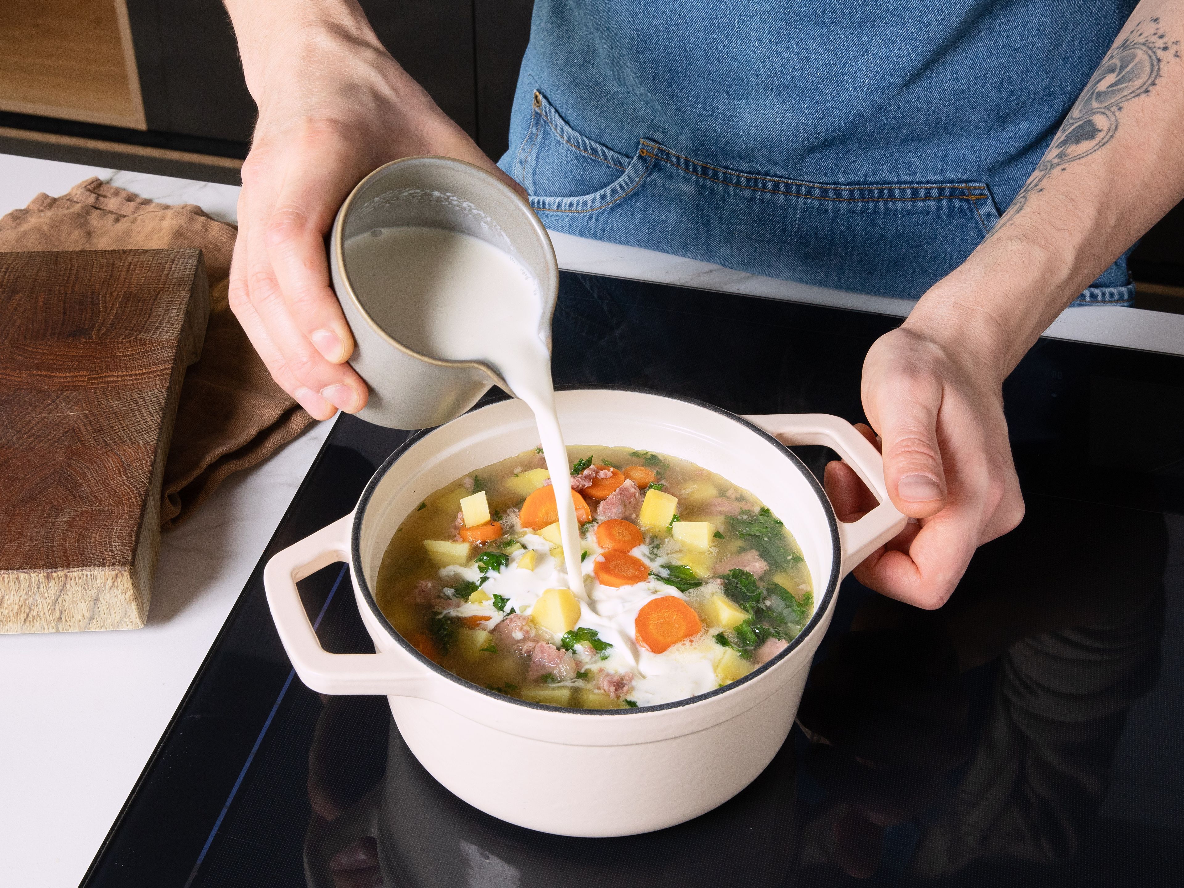 Den Grünkohl in den Topf geben und ca. 5 Min. garen. Sahne in die Suppe gießen, gut umrühren und mit Salz und Pfeffer abschmecken. Die Zuppa Toscana vor dem Servieren ca. 5 Min. ruhen lassen.