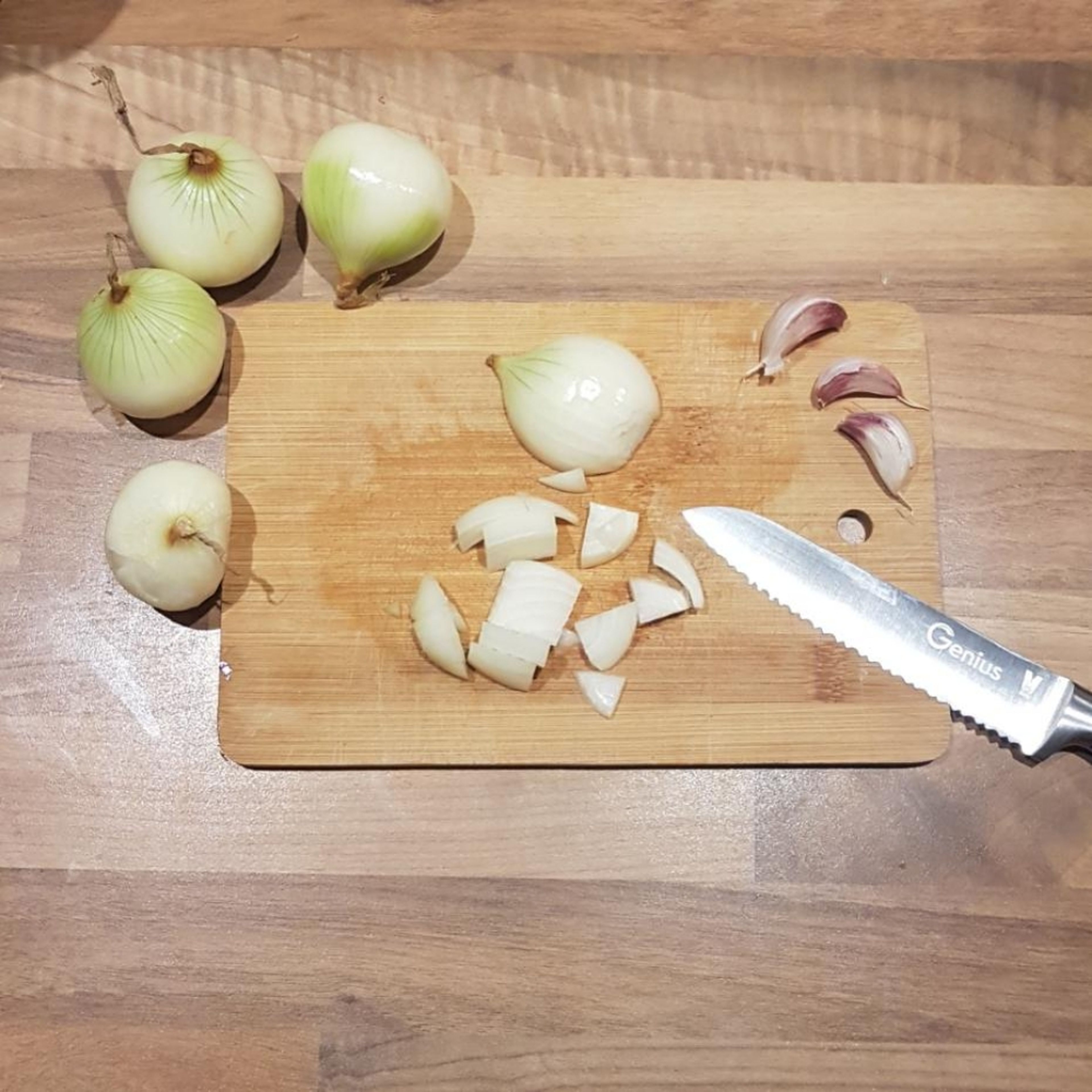 schneide Zwiebeln in grobe Stücke und hacke die Knoblauchzehen klein