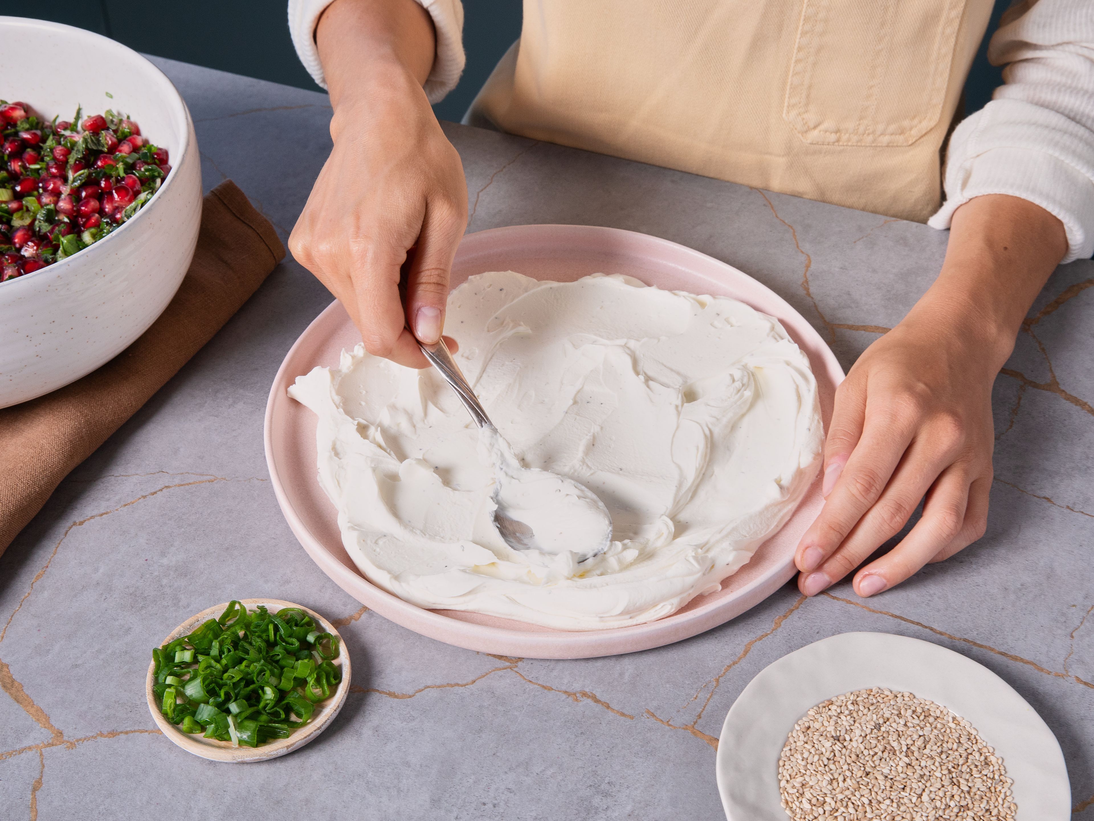 Den Frischkäse mit Salz und Pfeffer abschmecken und gleichmäßig auf einem Teller verteilen. Mittig eine weite Mulde eindrücken. Die Salsa hineingeben, mit Sesam bestreuen und mit Pita oder Brot genießen.
