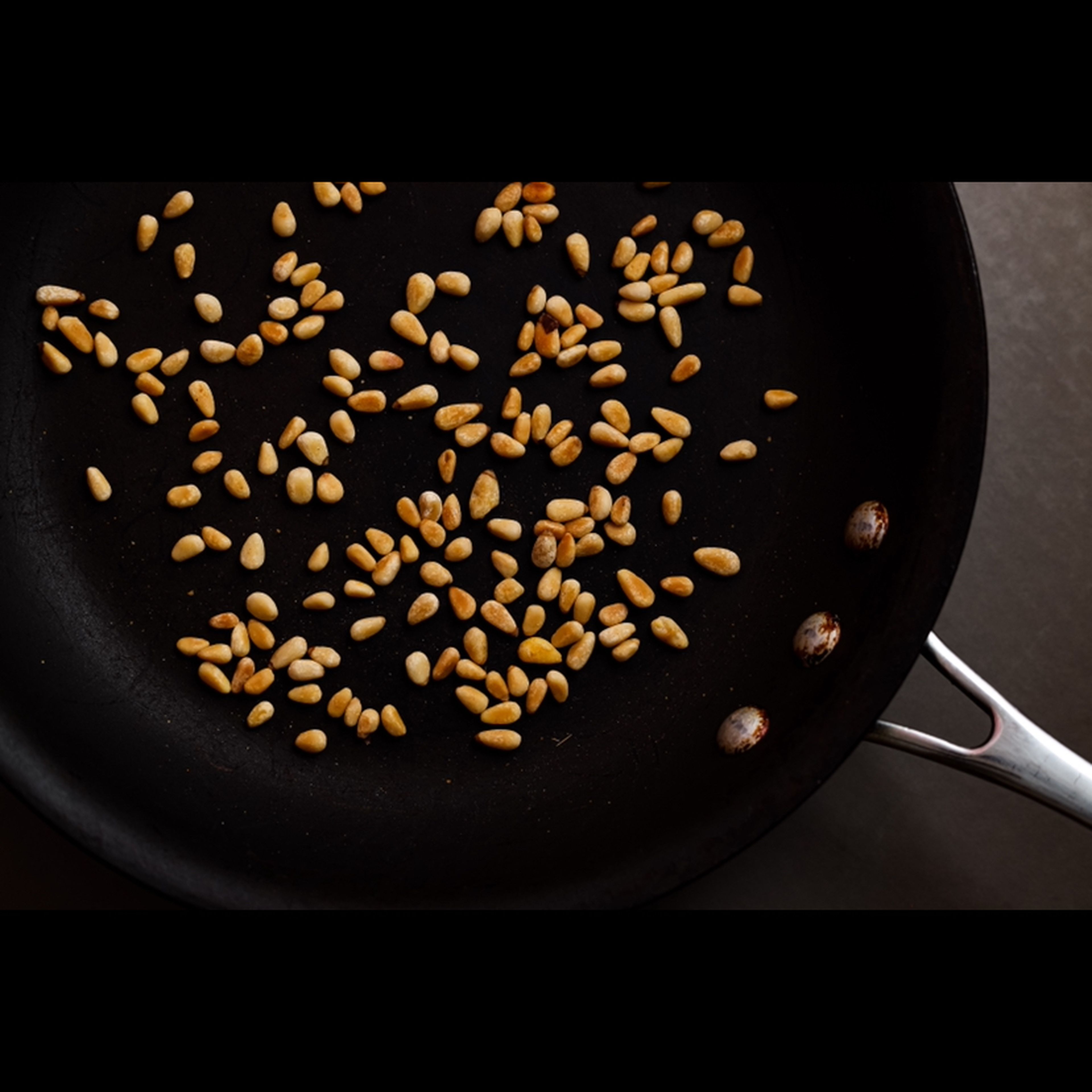 Toast the pine nuts in a pan until golden and fragrant.