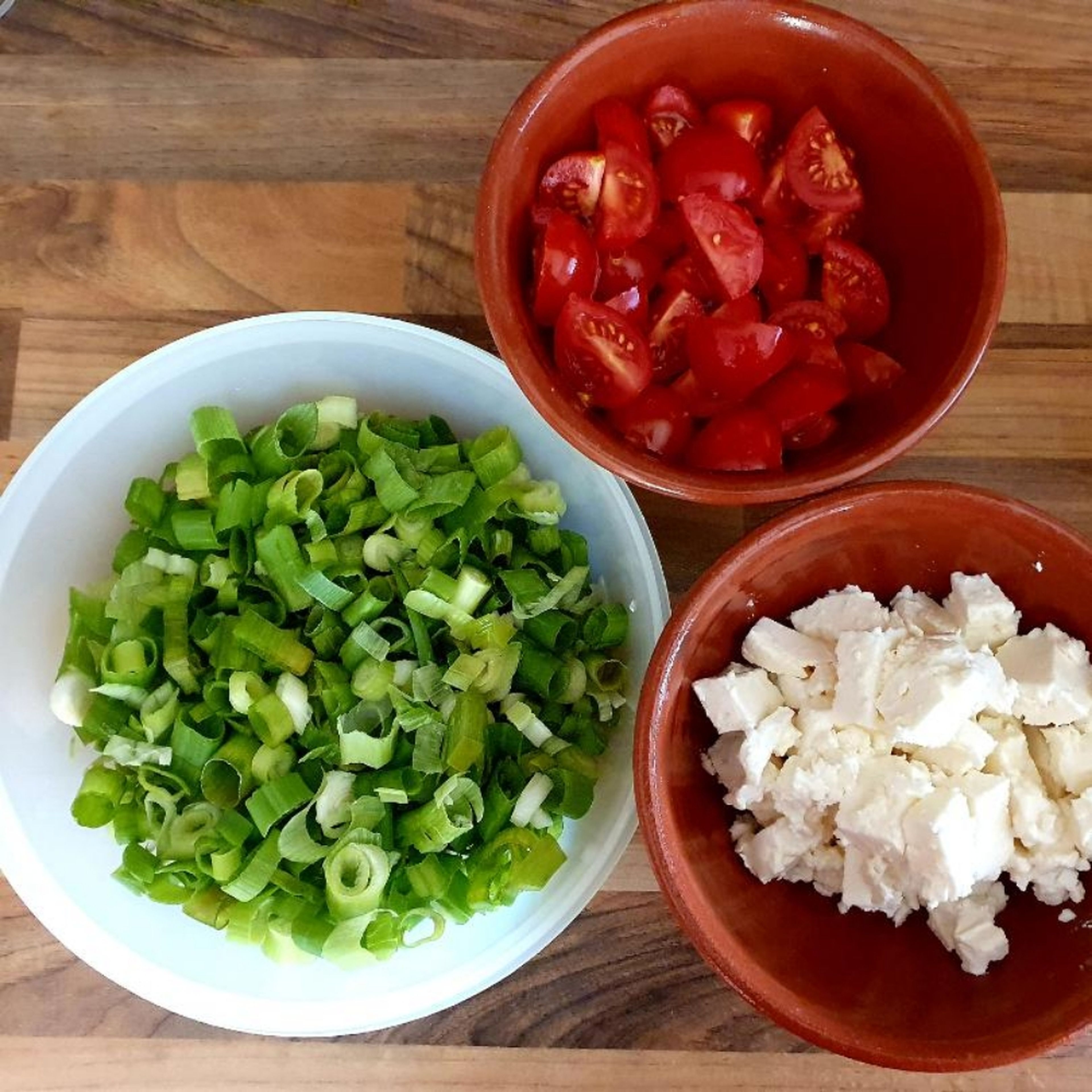 Tomaten, Frühlingszwiebeln und Fetakäse schneiden.