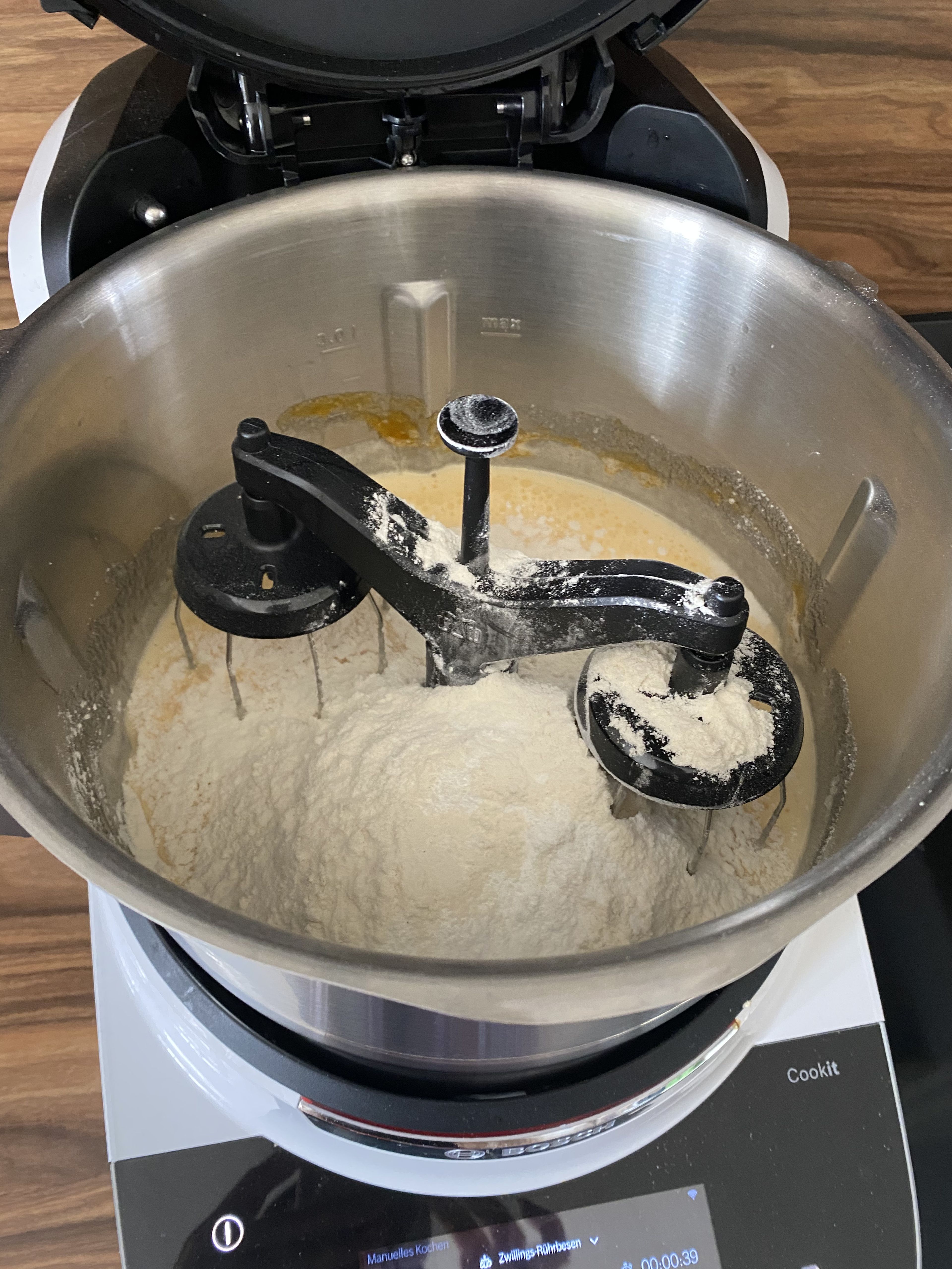 Das Mehl in den Zopf geben, Backpulver dazu und weiter rühren (Zwillings-Rührbesen | Stufe 6 | 15 Sek.). Gegebenenfalls Teig vom Rand mit dem Cookit Spatel nach unten schieben.