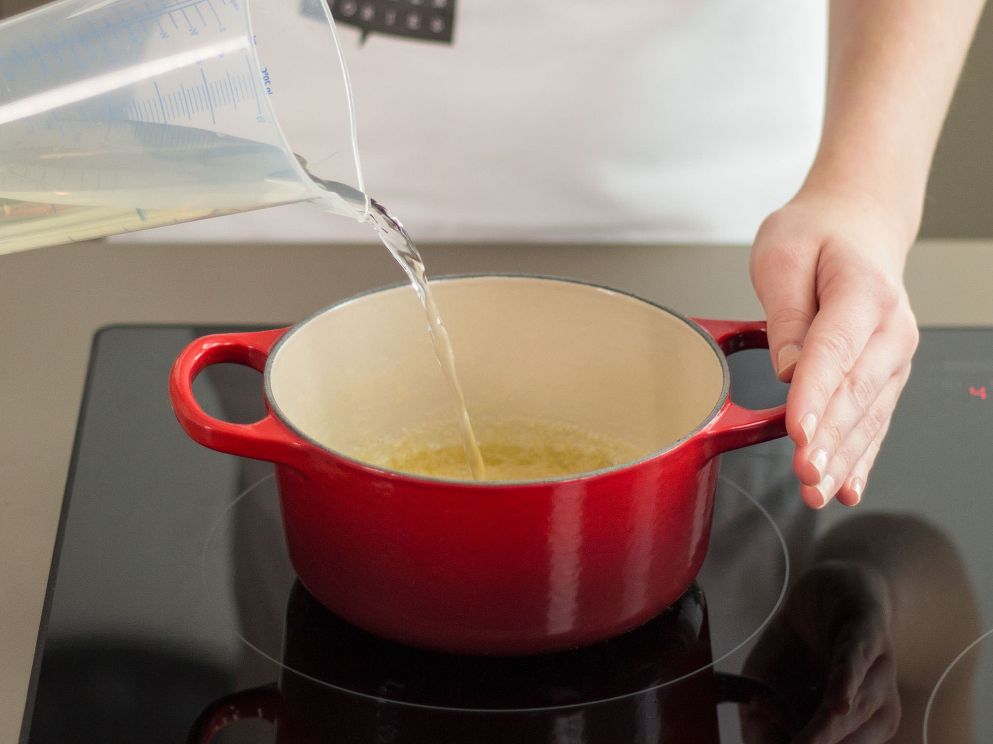 Butter in einem großen Topf bei mittlerer Hitze zerlassen. Mehl hinzufügen und unter ständigem Rühren erhitzen und anschließend mit Weißwein ablöschen.