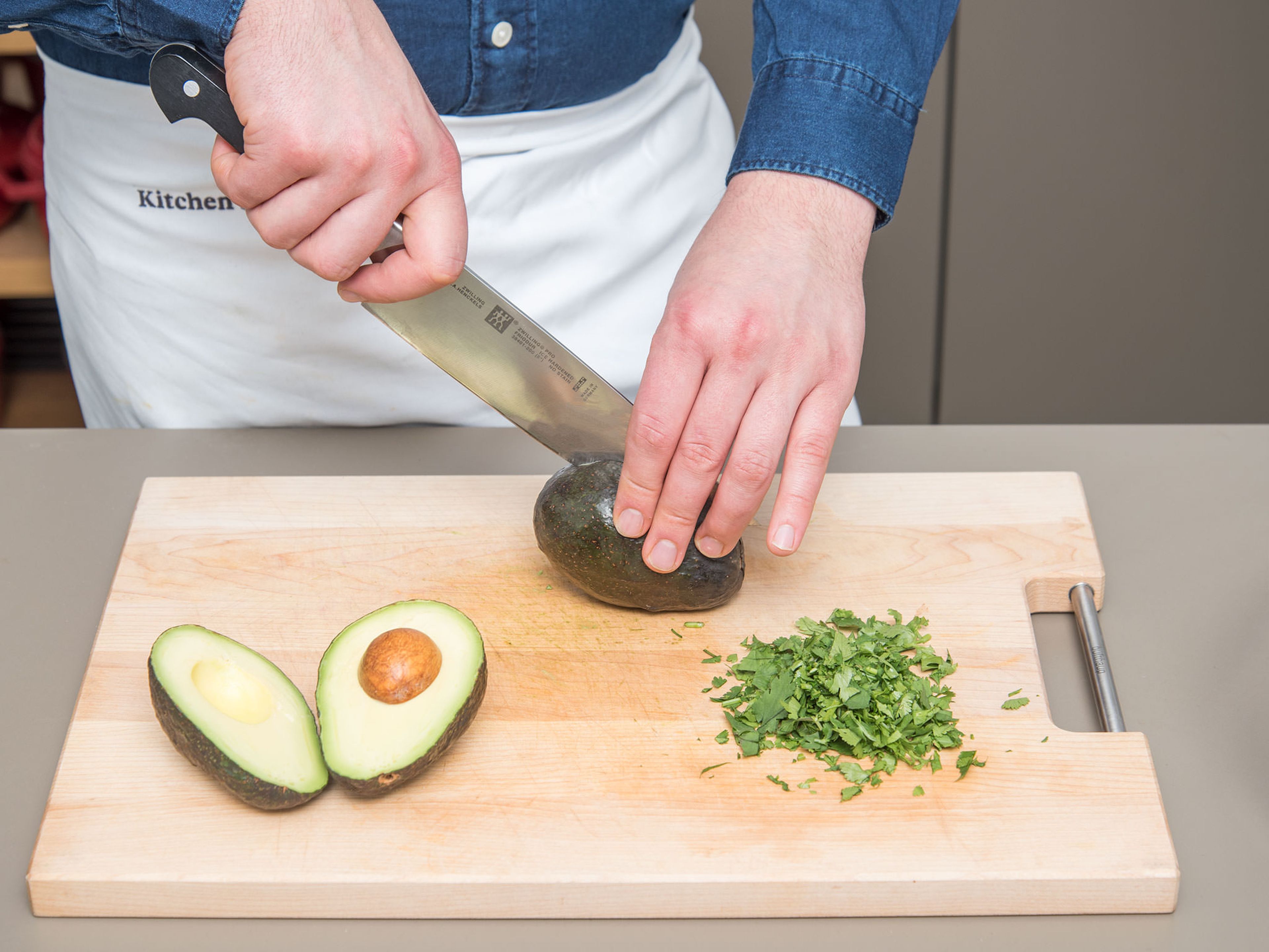 Meanwhile halve and peel avocados, remove the pit and dice the avocado flesh. Wash and finely chop cilantro.