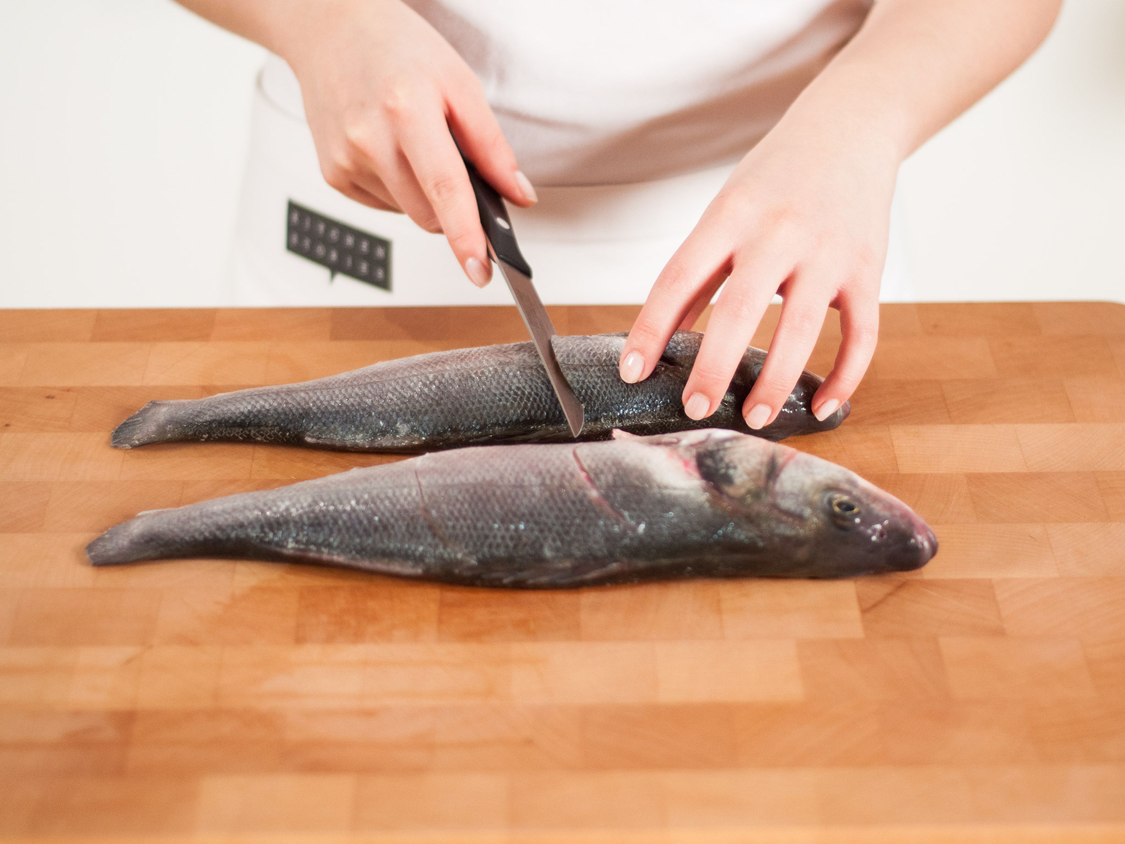 Place fish onto cutting board. Working with one fish at a time, use a sharp knife to make two cuts on each side of the fish.