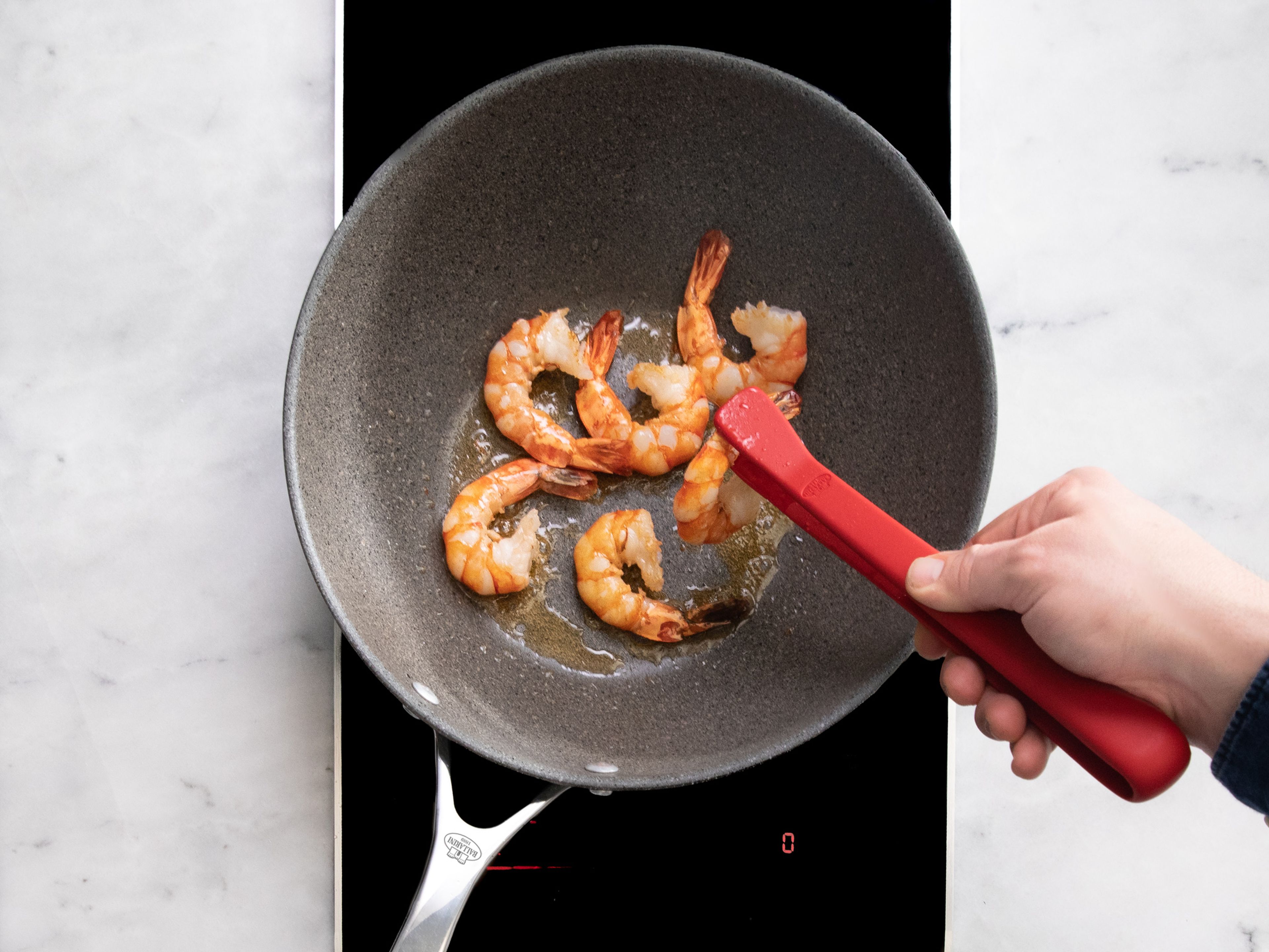 Heat a large frying pan over medium-high heat. Add vegetable oil and fry the shrimp on each side for approx. 2 min., then remove from the pan. Next fry the calamari rings. Add garlic and tomatoes and cook for approx. 2 min.