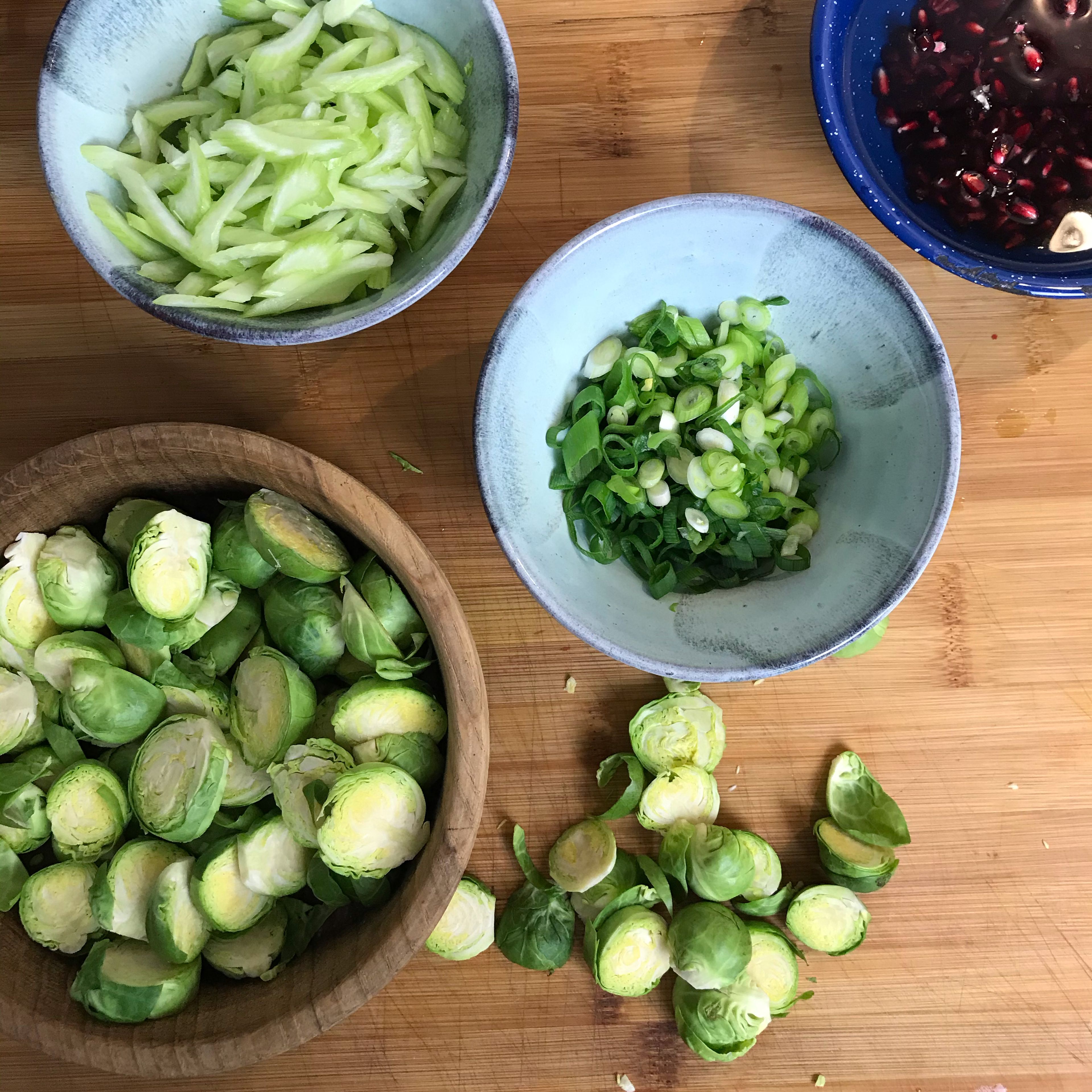 Remove the outer leaves from the Brussels sprouts (if they are brown or dirty) and cut into slices. Pull the strings from the celery and then cut into fine strips. Cut the spring onions into fine rings as well. Remove the pomegranate seeds. Wash the frisée, spin it and roughly tear it.
