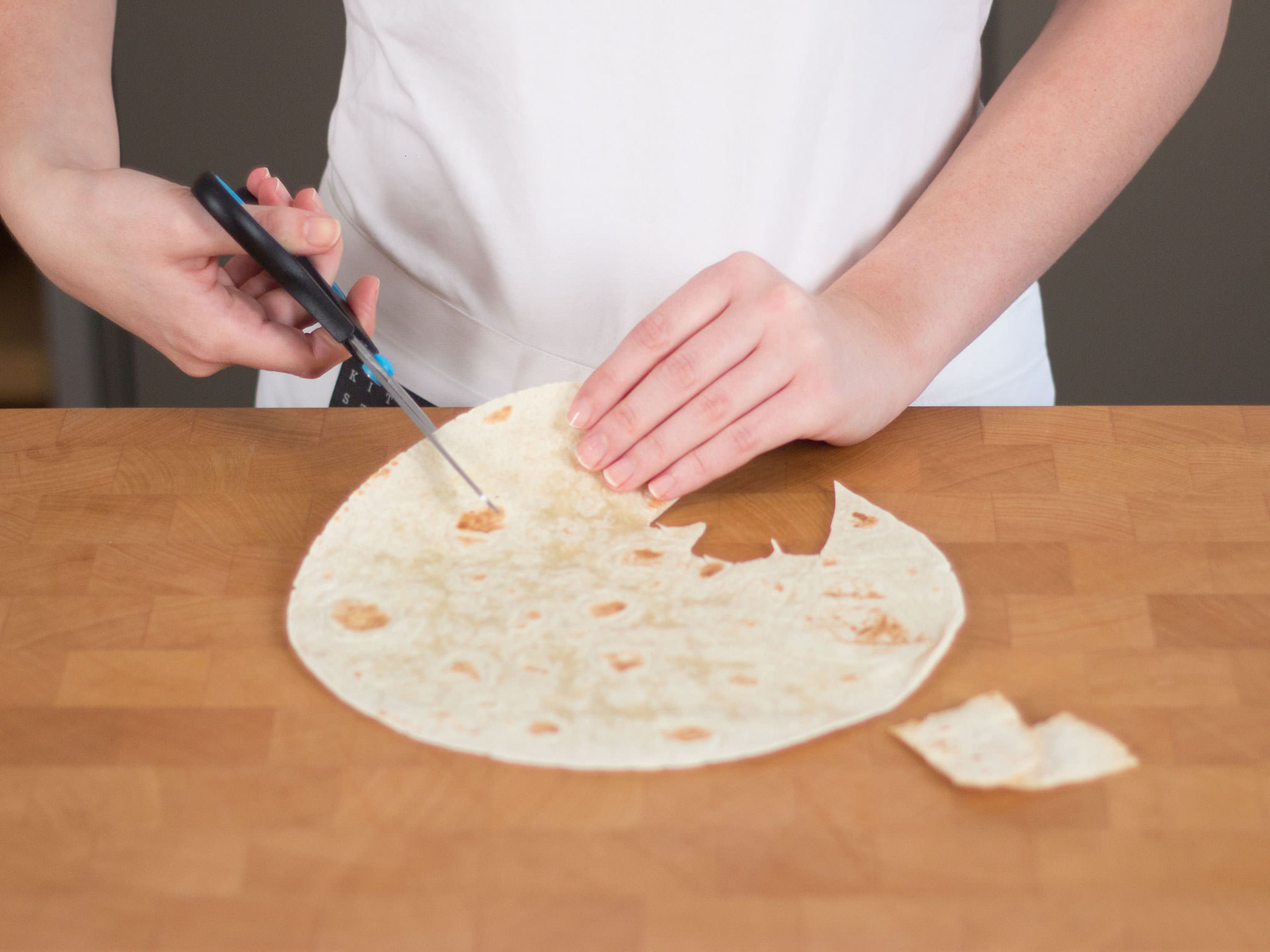 Using scissors, cut graveyard themed chips, such as headstones and ghosts, from tortillas. Place on a lined baking sheet, transfer to preheated oven, and bake at 150°C/300°F for approx. 10 – 15 min. until golden brown.