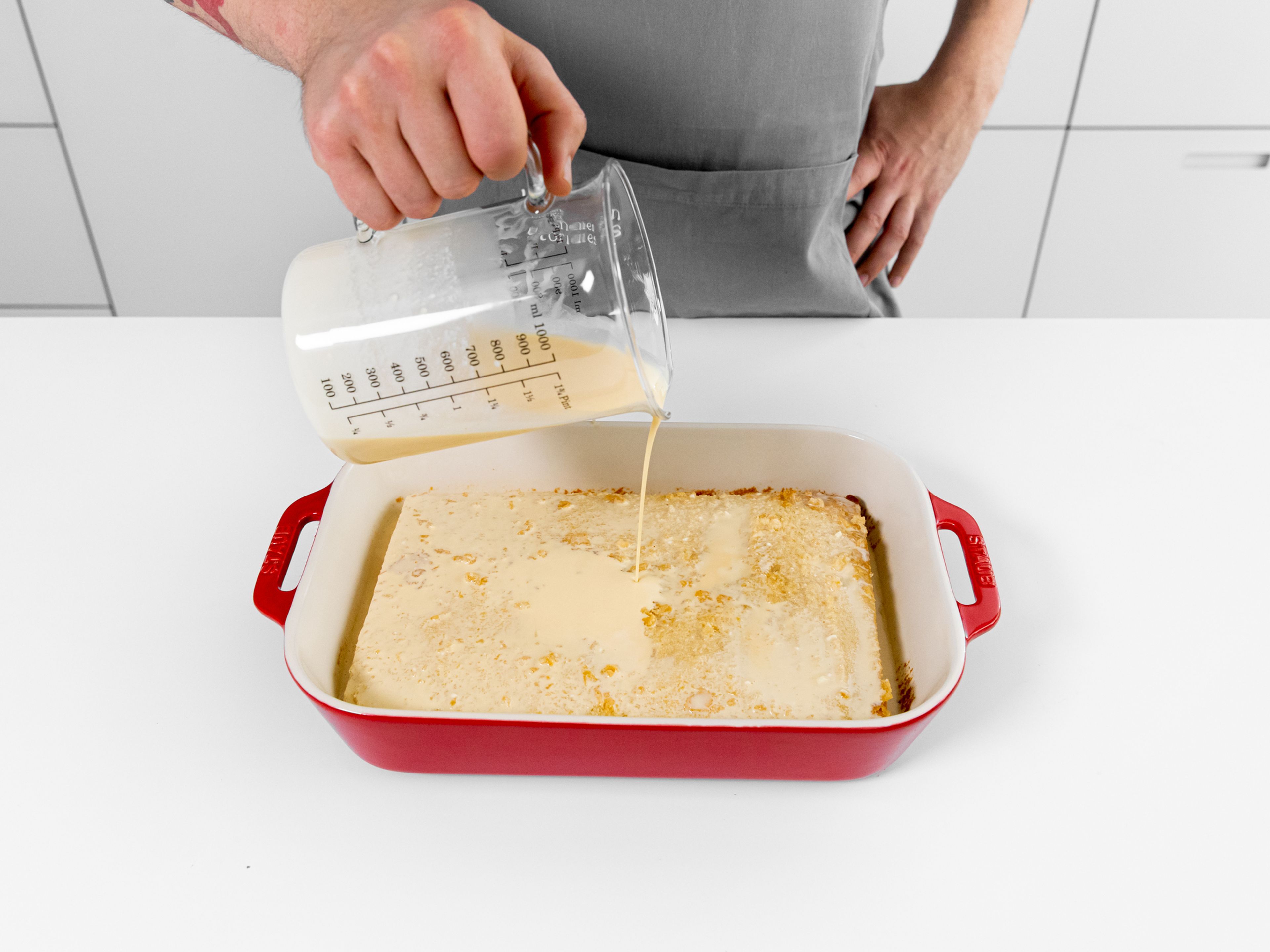 While the cake cools, add condensed milk, evaporated milk, heavy cream, and some vanilla extract to a large bowl and whisk to combine. Level the cake on the top and sides with a knife, then transfer it back to the baking pan. Pour the cake tres leches cake soak over the cake evenly. Cover the pan tightly with plastic and transfer to the fridge to cool for at least 3 hr.
