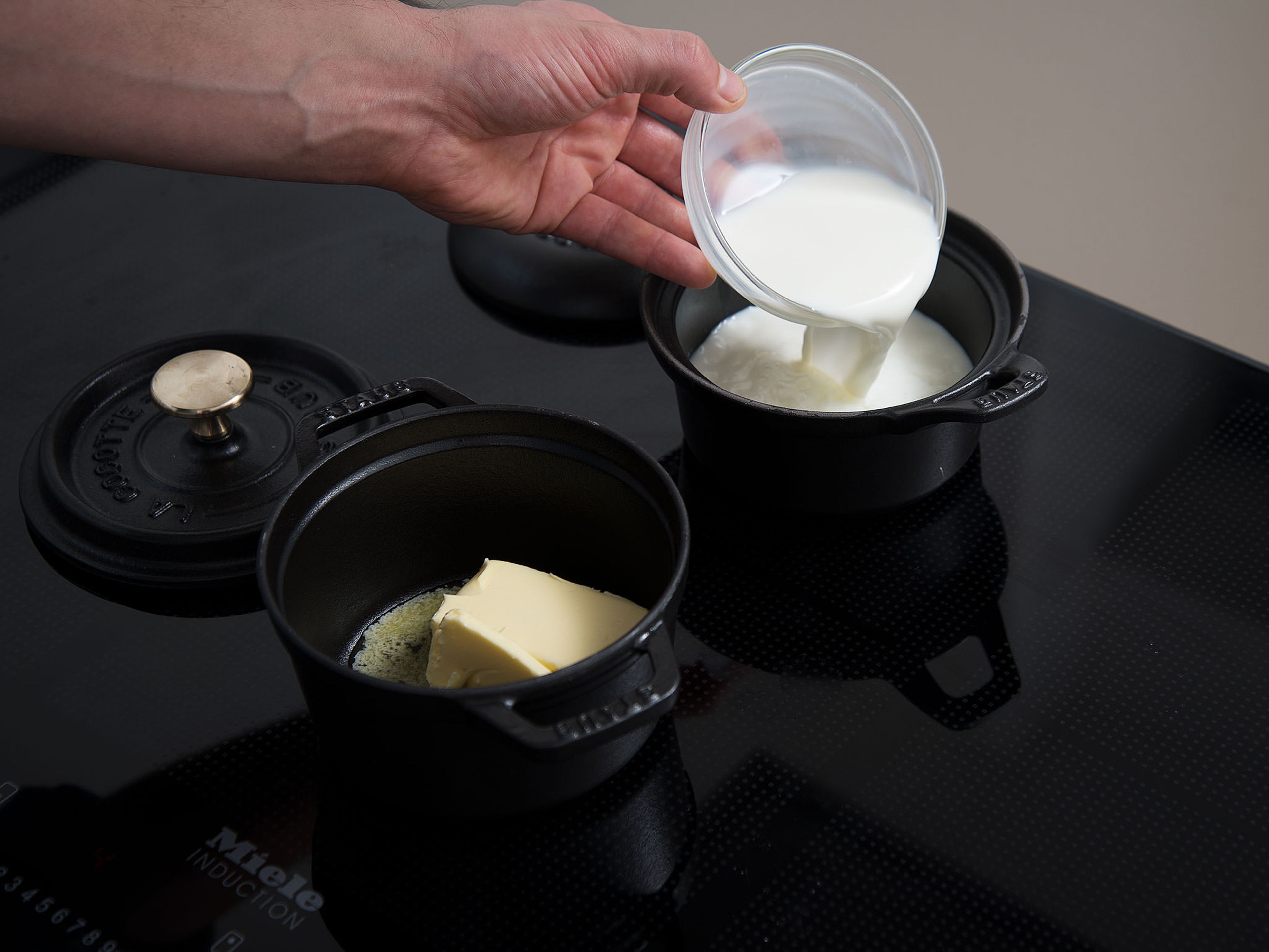 Milch und Wasser in einem kleinen Topf bei niedriger bis mittlerer Hitze erwärmen. Hefe zugeben und verrühren. Butter in einem weiteren kleinen Topf bei mittlerer bis hoher Hitze erwärmen. Mehl und Salz in eine große Schüssel geben und in der Mitte eine Mulde formen.