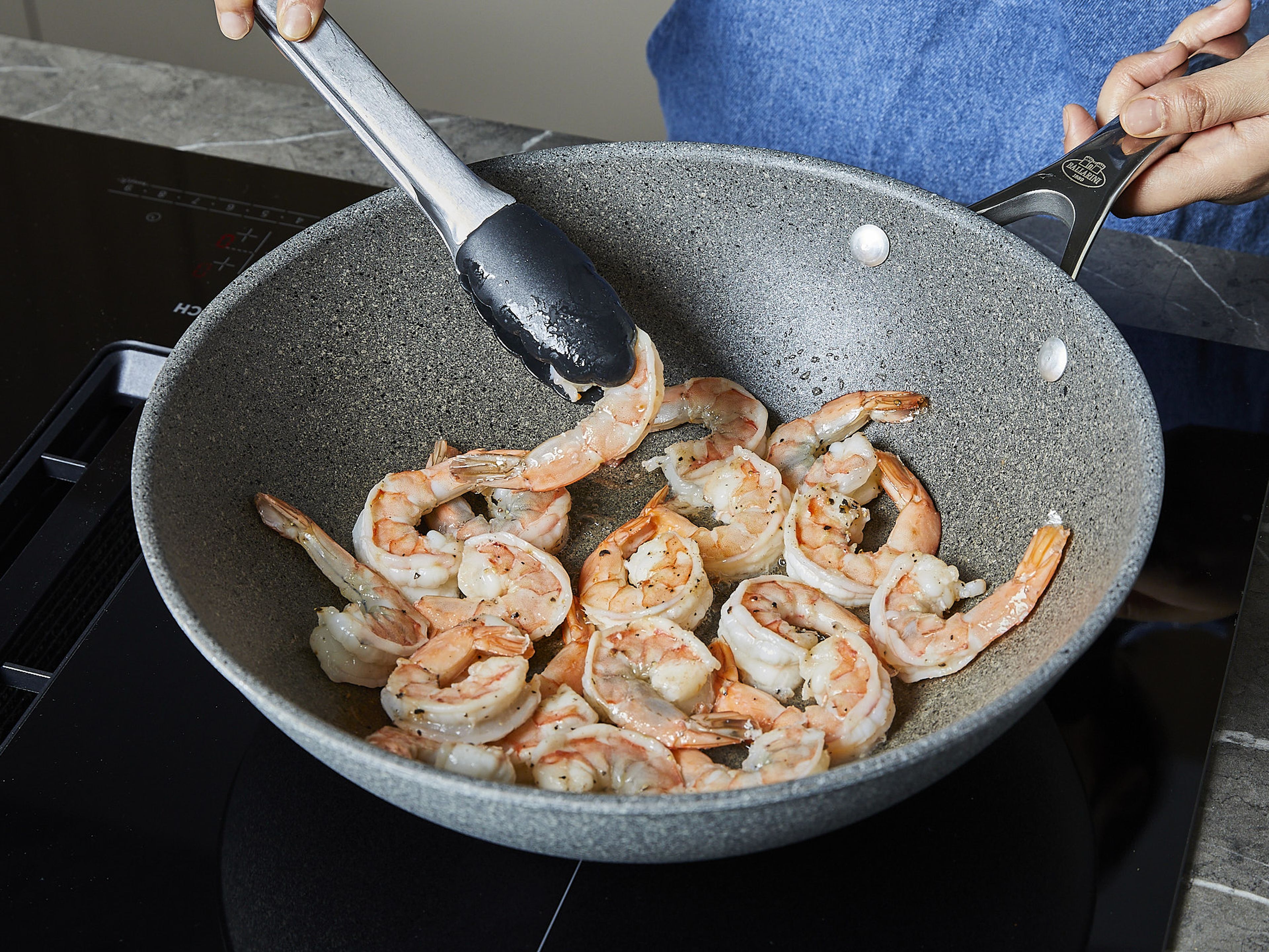 In a frying pan, heat oil over medium-high heat. Add shrimps and fry until they turn pink on both sides, approx. 1–2 min. per side. Remove from the pan and set aside. In the same pan, add more oil if needed, then add ginger, garlic, and chili flakes and fry until fragrant. Then add asparagus and fry for approx. 2 min.