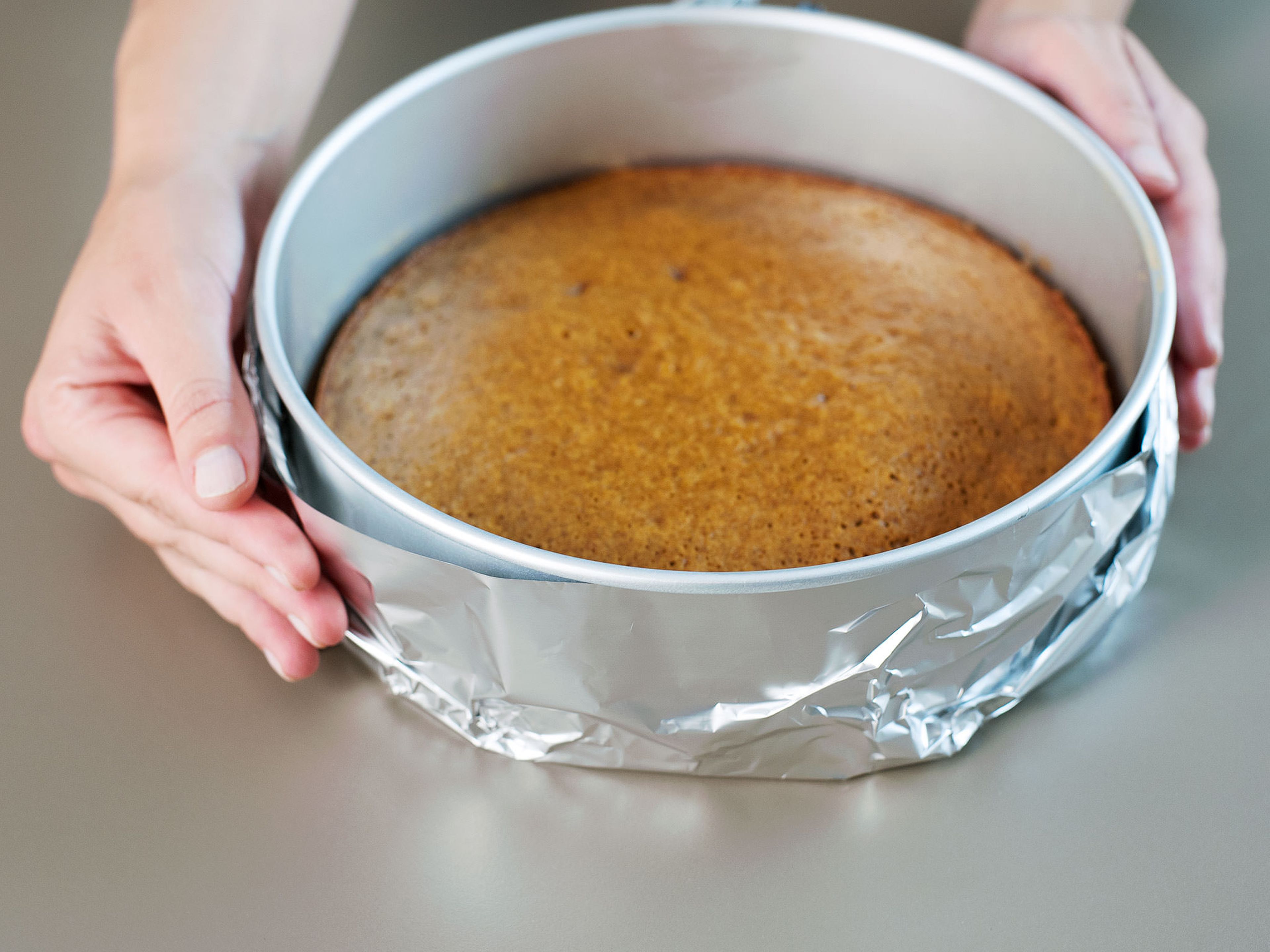 Wrap the baking form in 2 sheets of aluminum foil. Bring some of the water to a boil. Reduce the oven temperature to 160°C/320°F.