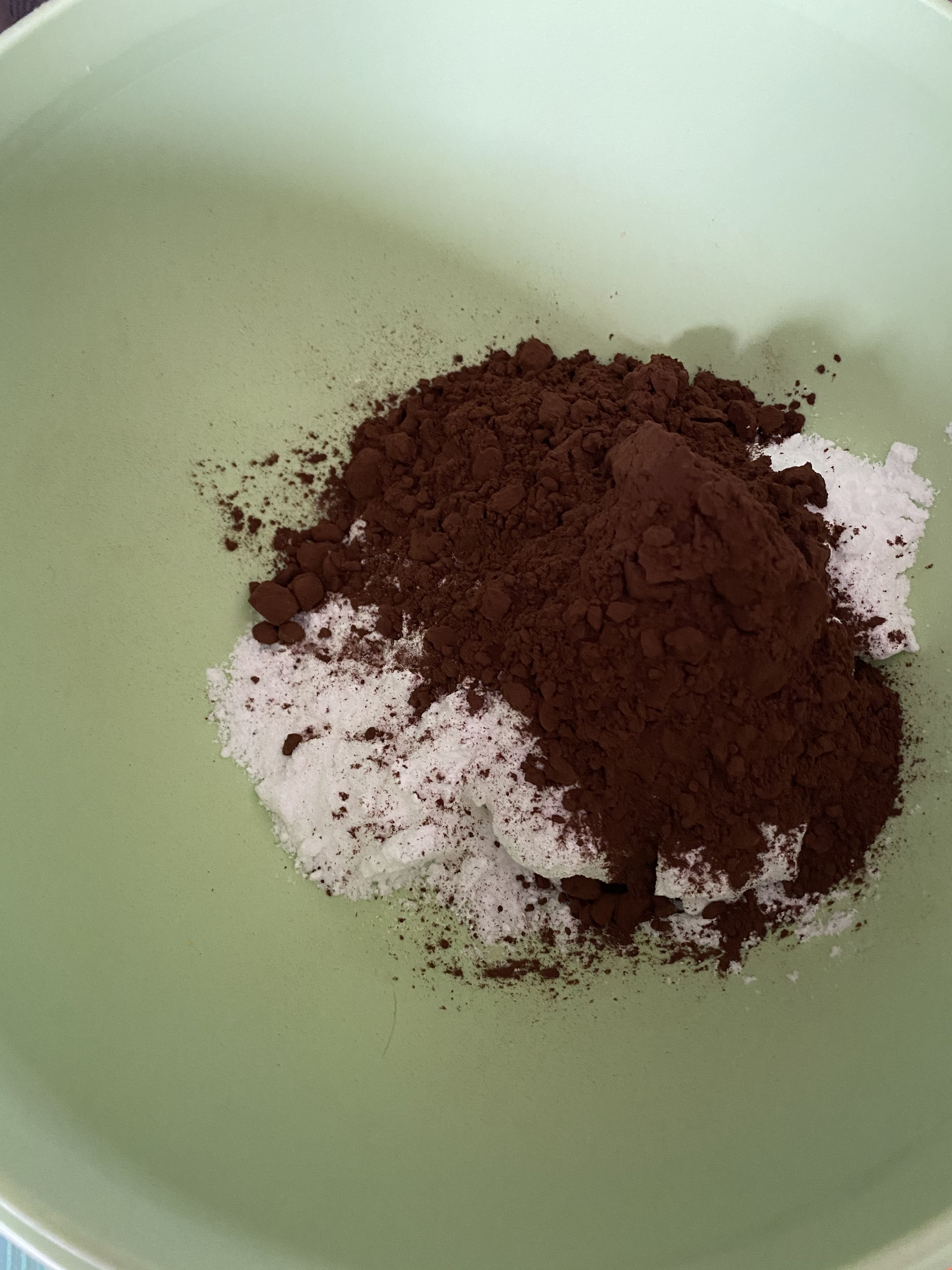 Für die Glasur den Puderzucker, den Kakao, Salz und das Kaffeepulver in eine separate Schüssel geben, vermischen und dann tropfenweise Wasser zugeben, bis eine cremige streichbare Masse entsteht.