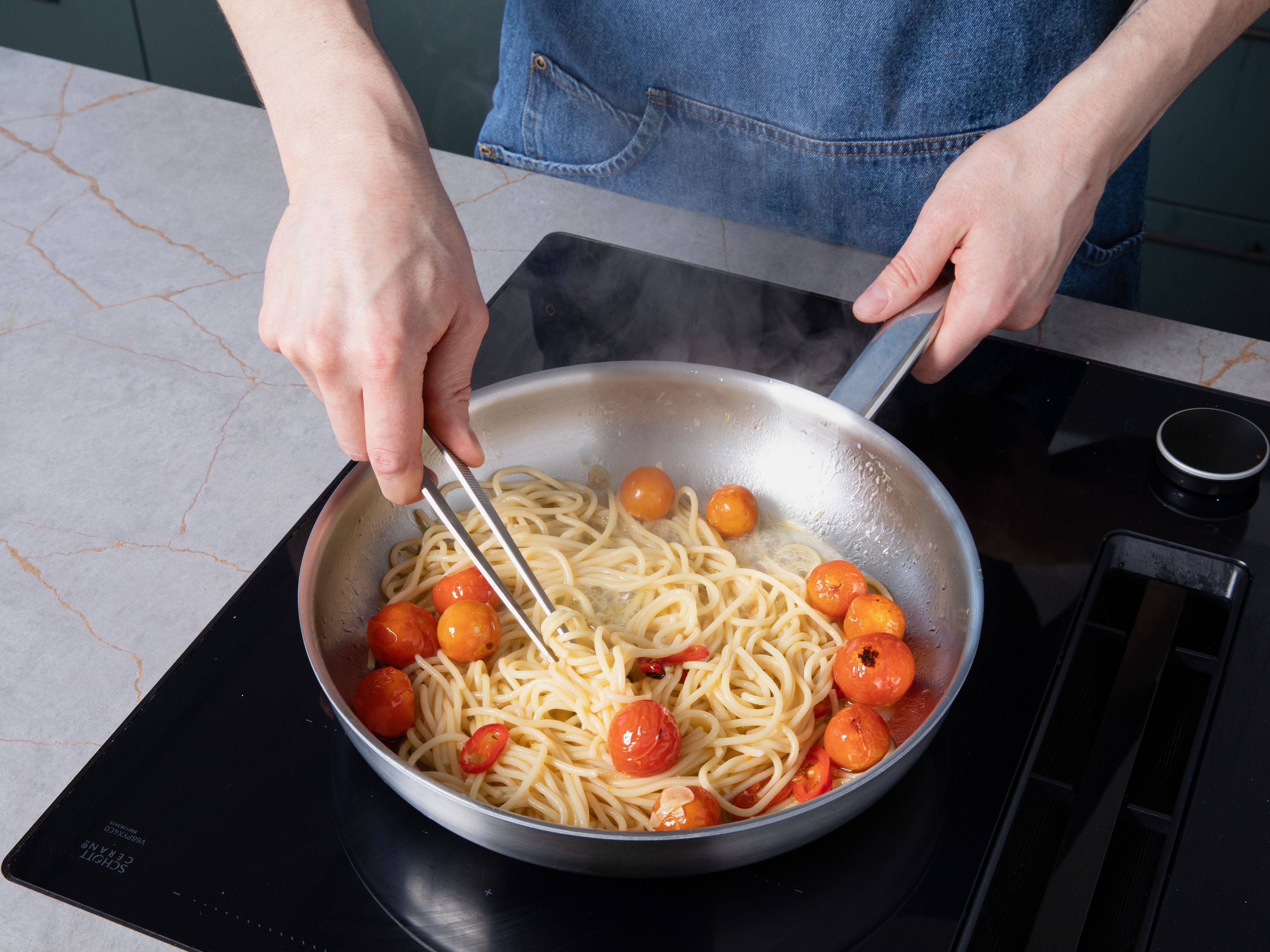 Die fertig gegarten Spaghetti in die Pfanne geben und mit der confierten Tomatenmischung vermengen. Bei Bedarf etwas Kochwasser hinzufügen und alles gut verrühren, bis eine samtige Sauce entsteht. Die Pasta auf Tellern anrichten, je eine Burrata darauf zupfen, mit etwas Balsamico-Creme beträufeln und großzügig mit Knoblauch-Panko bestreuen. Mit frischem Basilikum und Pfeffer servieren.