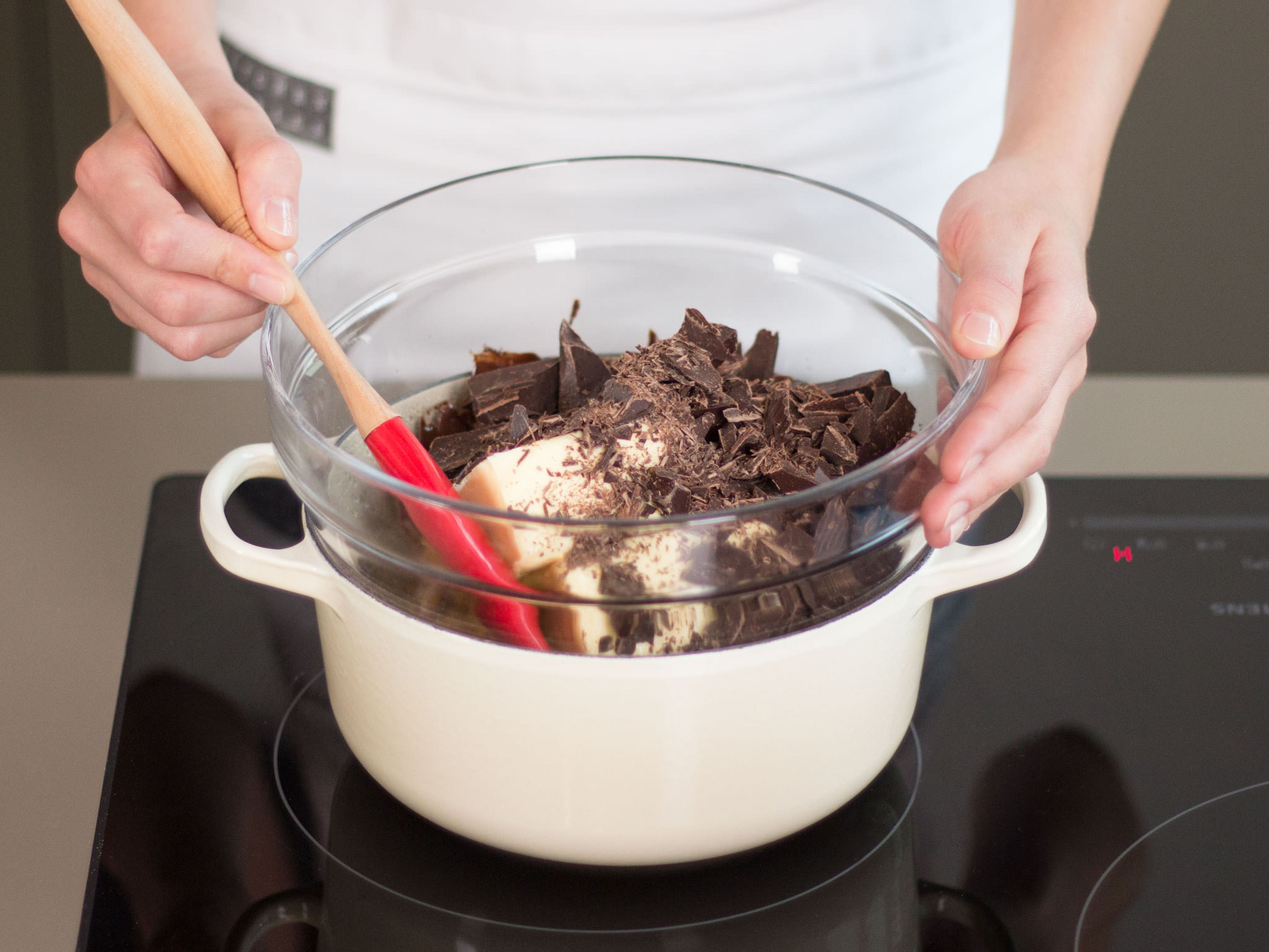 Preheat oven to 180°C/350°F. Heat a little water in a large saucepan and bring it to a boil at medium-high heat. Reduce heat and place a large bowl on top as a double boiler. Add butter and chocolate to bowl and stir until melted.