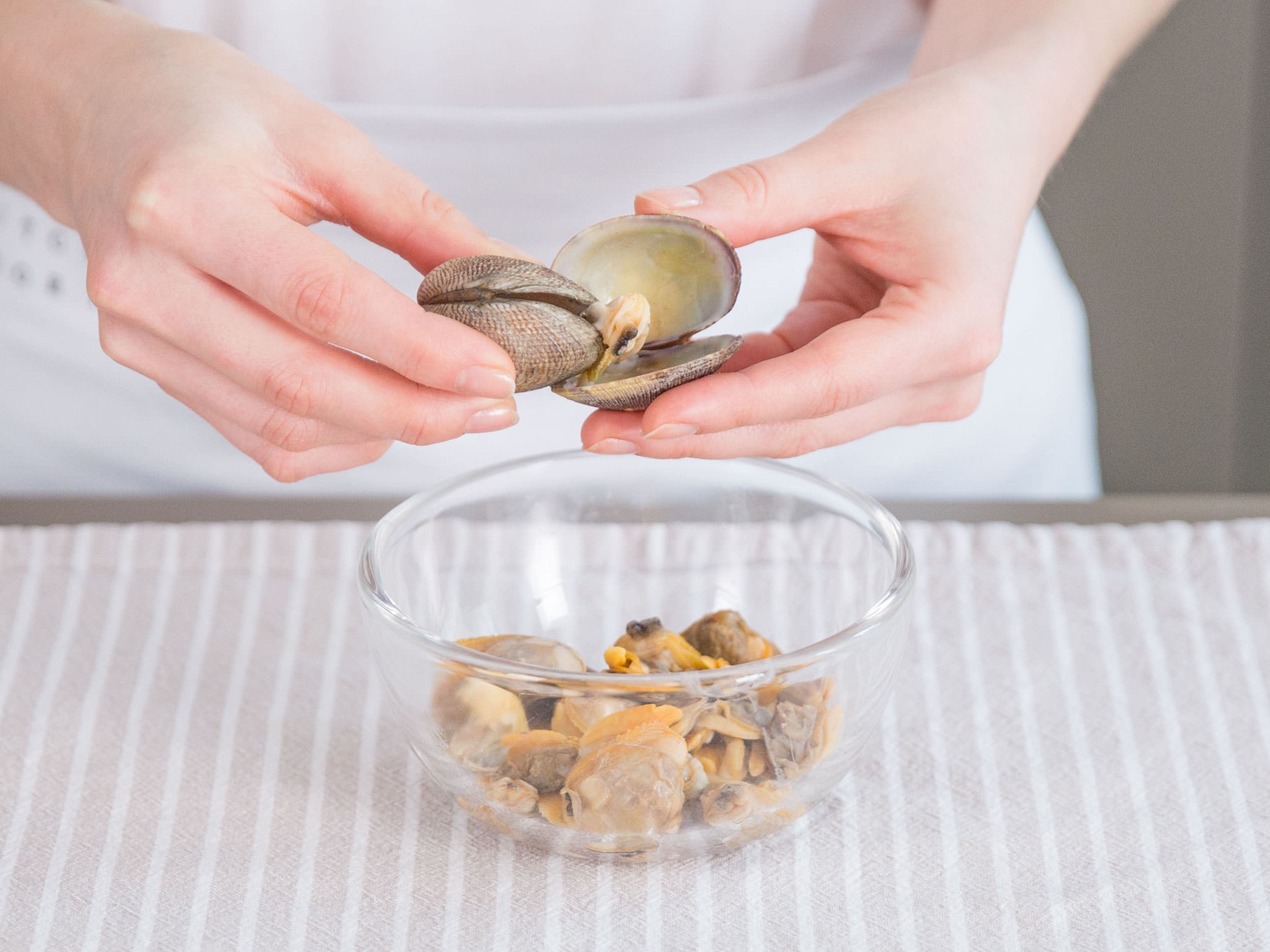 In a large saucepan, heat fish broth on medium heat. Add clams and cook on low heat for approx. 1 – 2 min. Remove from broth with a slotted spoon, reserve fish stock, and separate clams from shell. Set aside.