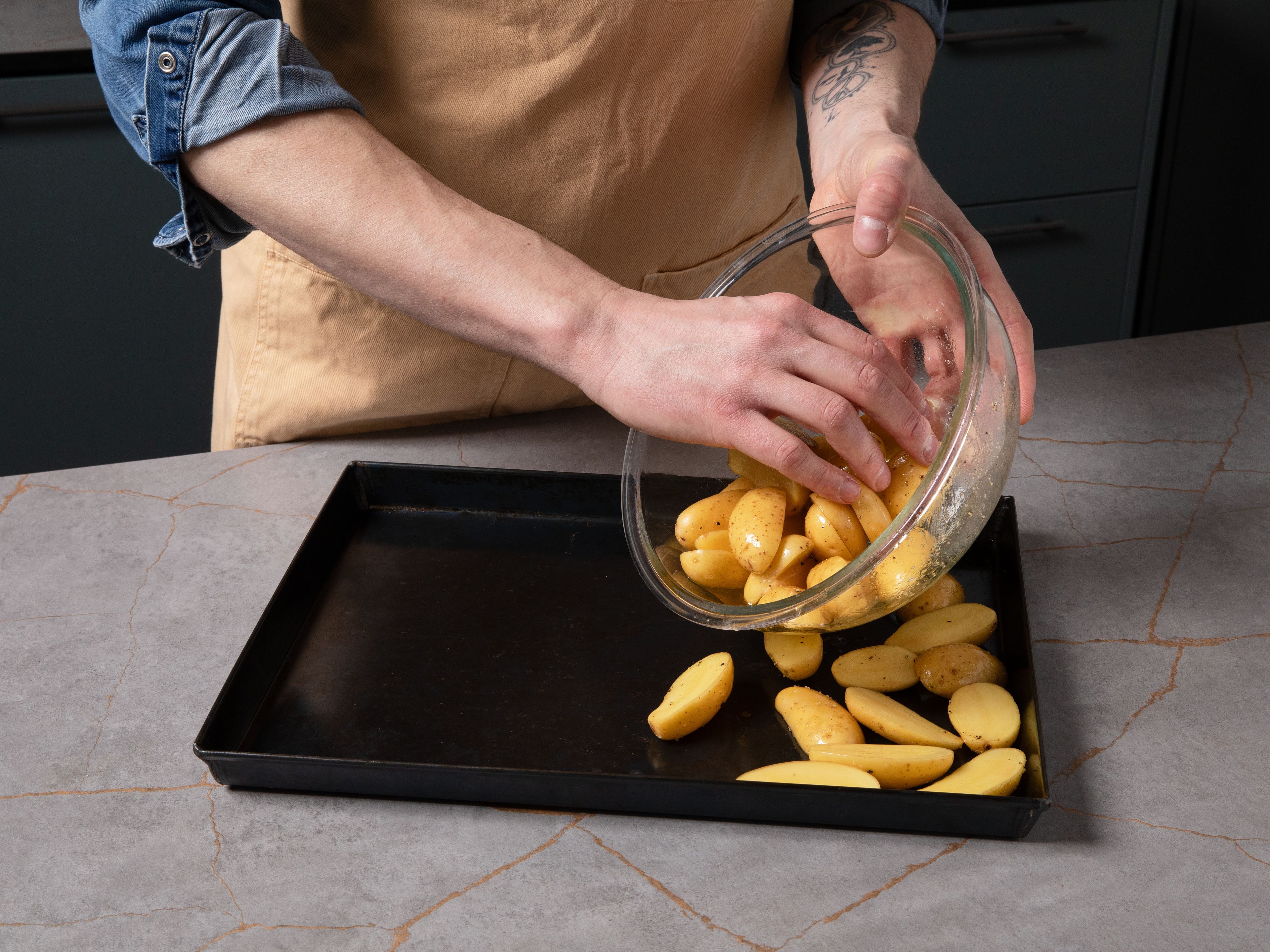 Preheat the oven to 200°C/ 392°F. Depending on the size, halve or quarter the potatoes and toss them in a bowl with olive oil, salt, and pepper. Spread them out on a baking sheet lined with parchment paper, leaving some space for the salmon and asparagus. Pre-bake the potatoes for approx. 10 min.