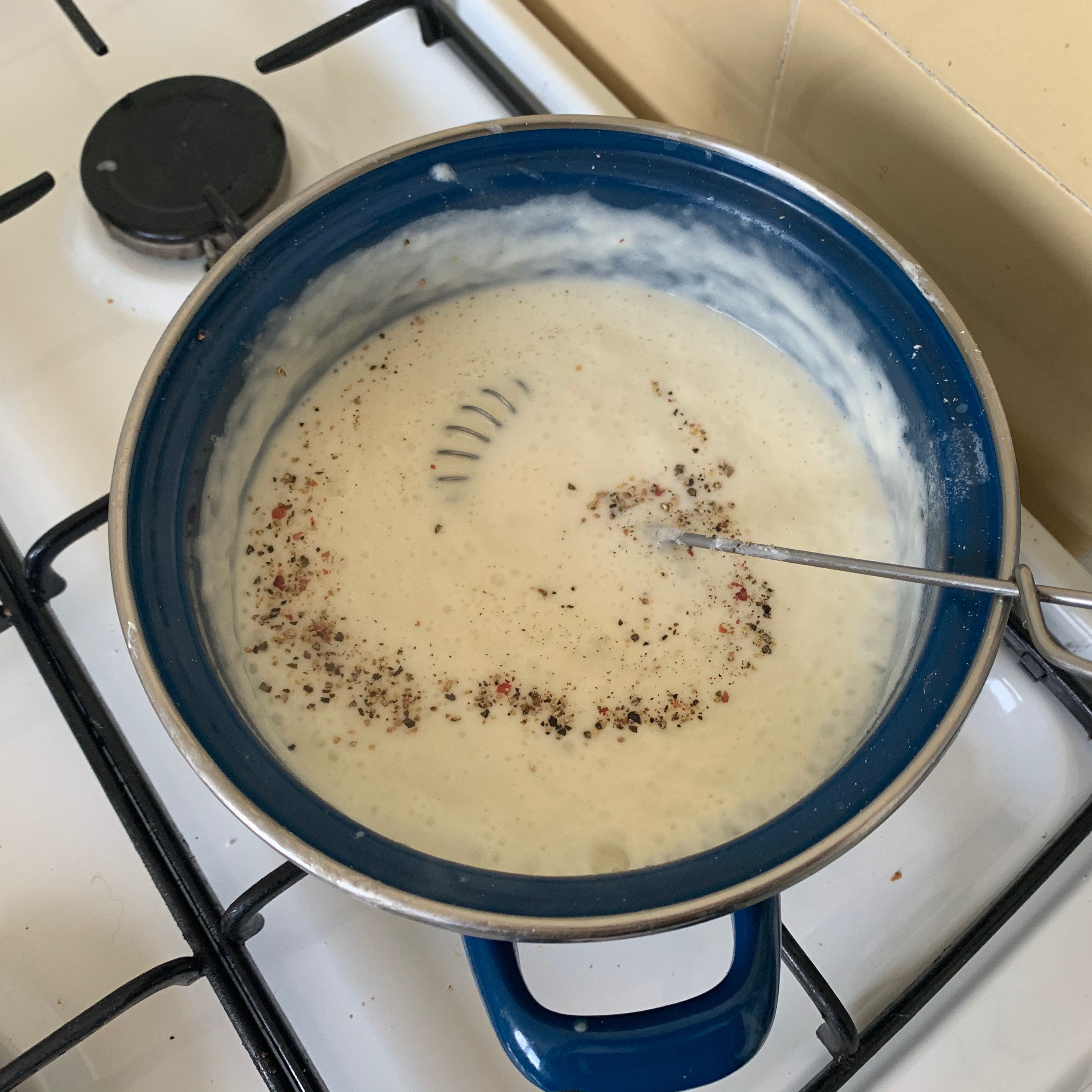 Gradually pour in the milk, stirring constantly, bring to a boil. Simmer on low heat for 10-15 min. Stir occasionally and add cream cheese. If the béchamel sauce becomes too thick, carefully add a little water. Season with nutmeg, salt and pepper.