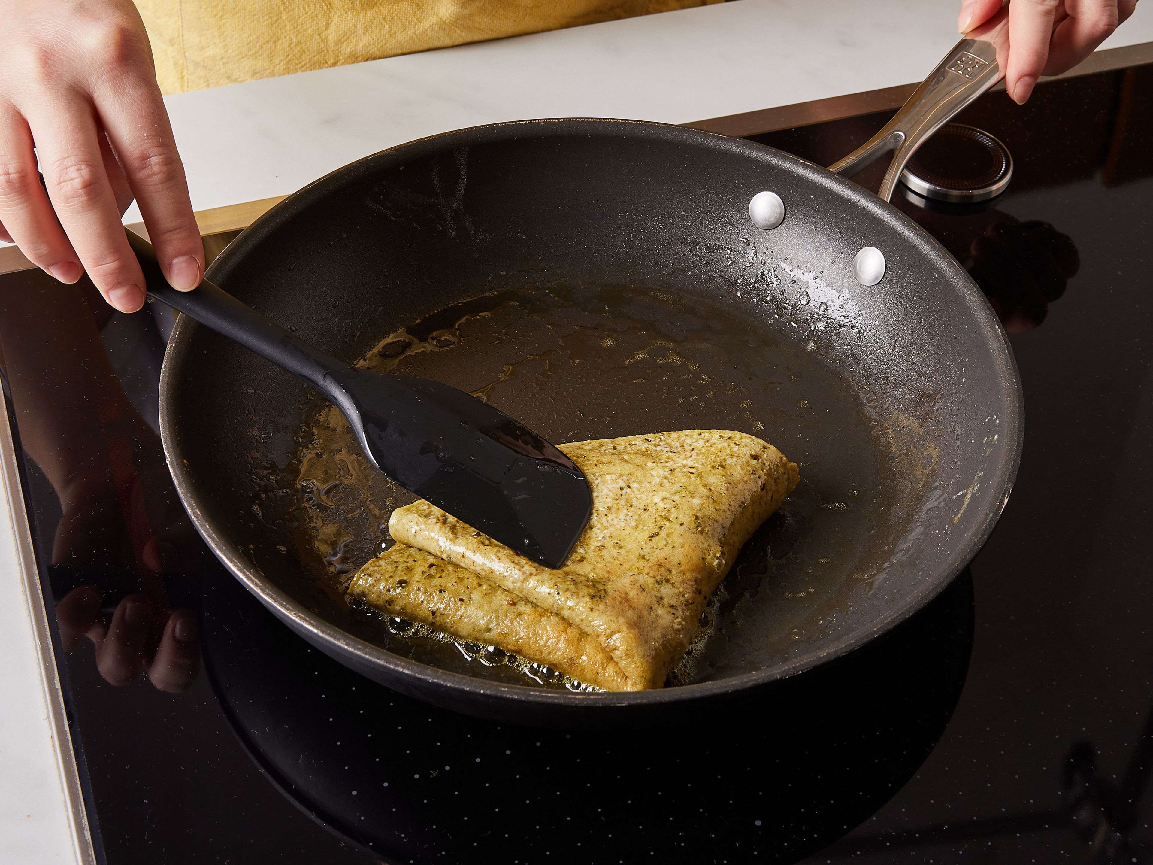 Die Eier in eine Schüssel geben. Pesto hinzufügen und beides mit einem Schneebesen verquirlen. Mit Salz und Pfeffer würzen. Restliche Butter in die Pfanne geben. Sobald sie geschmolzen ist, die Eier in die Pfanne gießen und ca. 3 Min. stocken lassen, oder bis die Unterseite des Omelettes fest wird. Das Omelette zusammenklappen und ca. 1 Min. weiterbraten.
