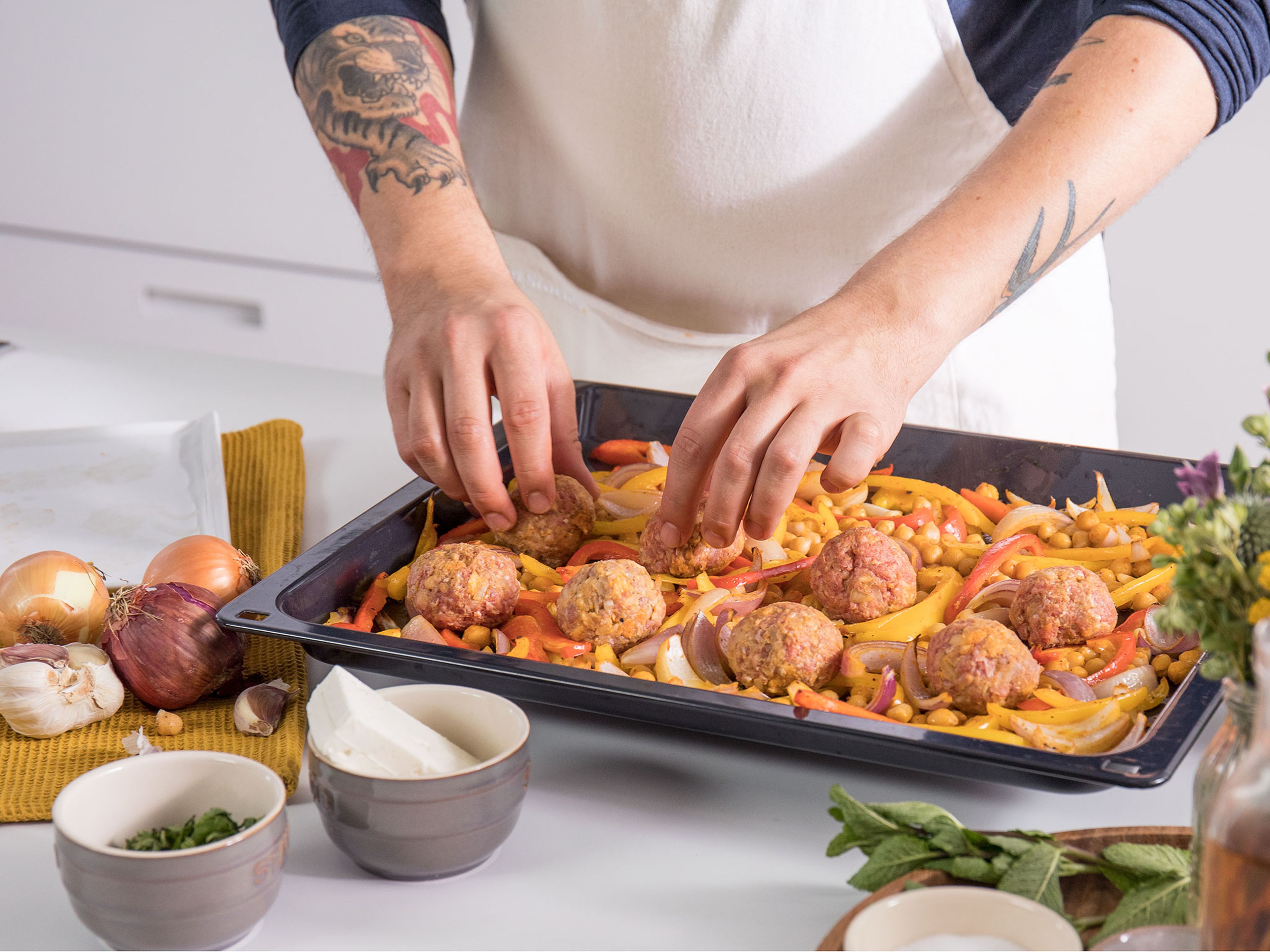Spread the vegetables on a baking sheet and bake for approx. 10 min. After 10 min., scatter the meatballs on top of vegetables and bake for approx. 15 – 20 min. more.