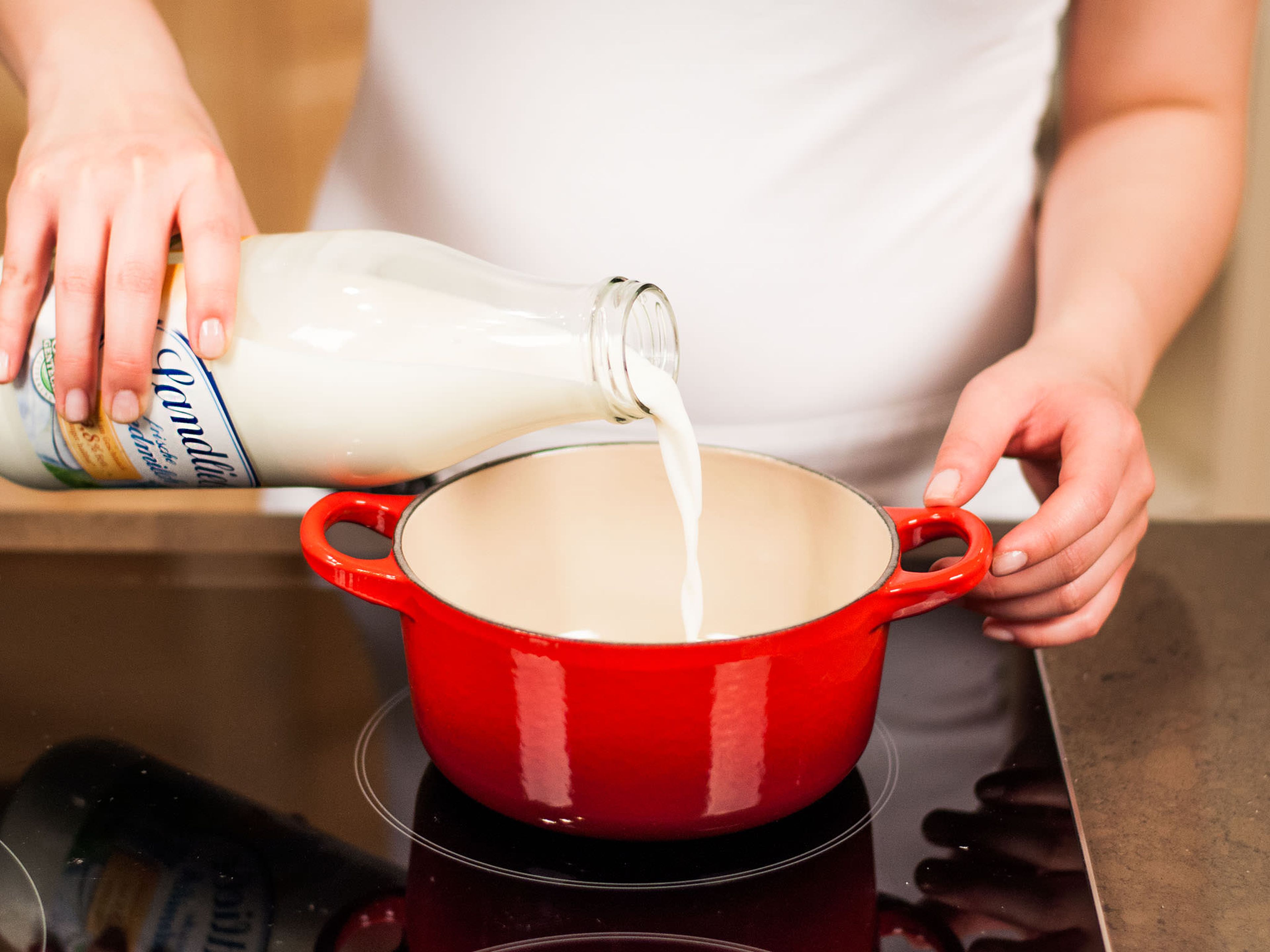 Milch mit Zucker vorsichtig zum Köcheln bringen. Anschließend die vorbereitete Eigelbmasse hinzugeben und unter stetigem Rühren stocken lassen.