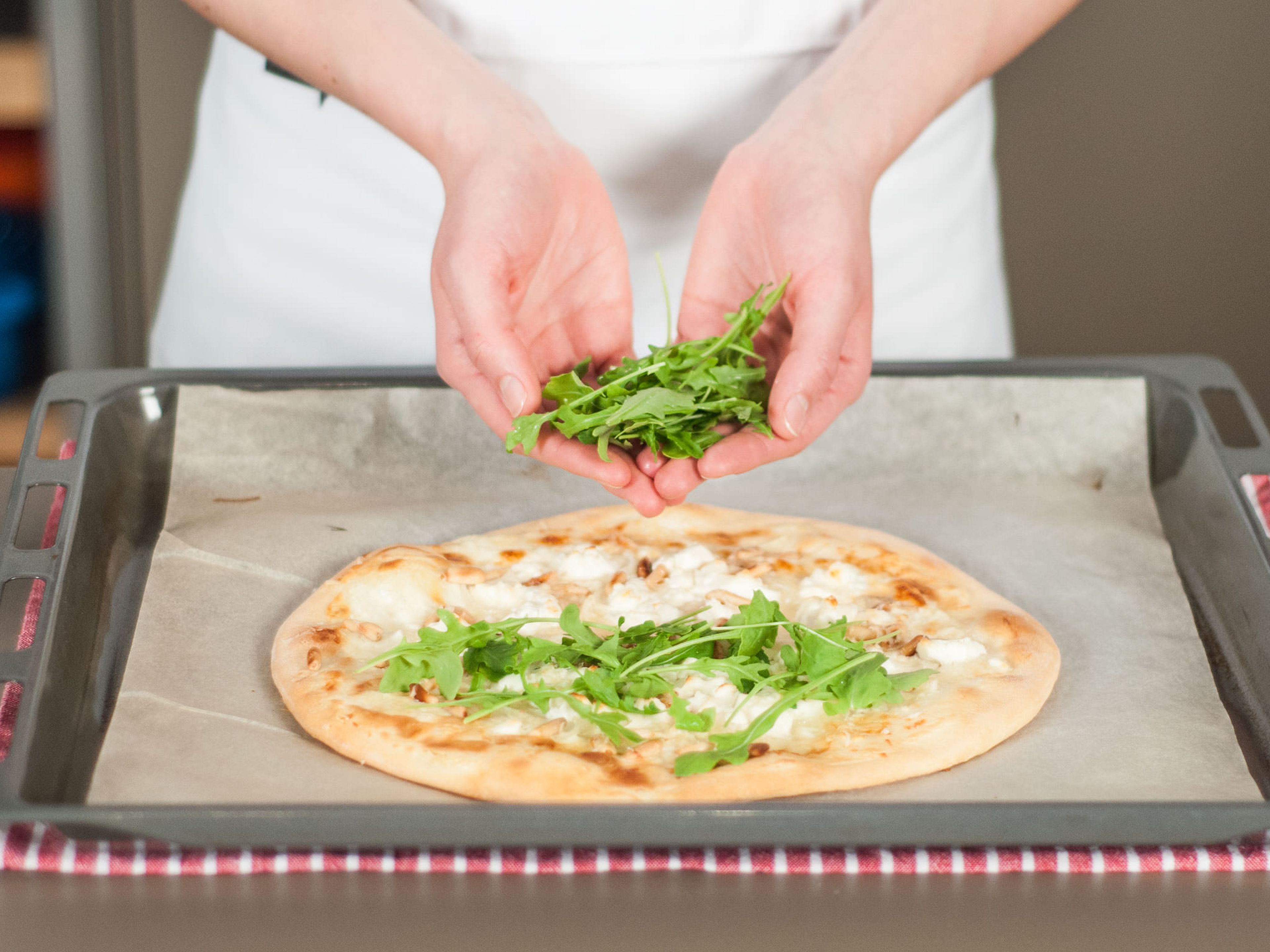 Remove pizza from oven. Season with black pepper and garnish generously with arugula. Enjoy!