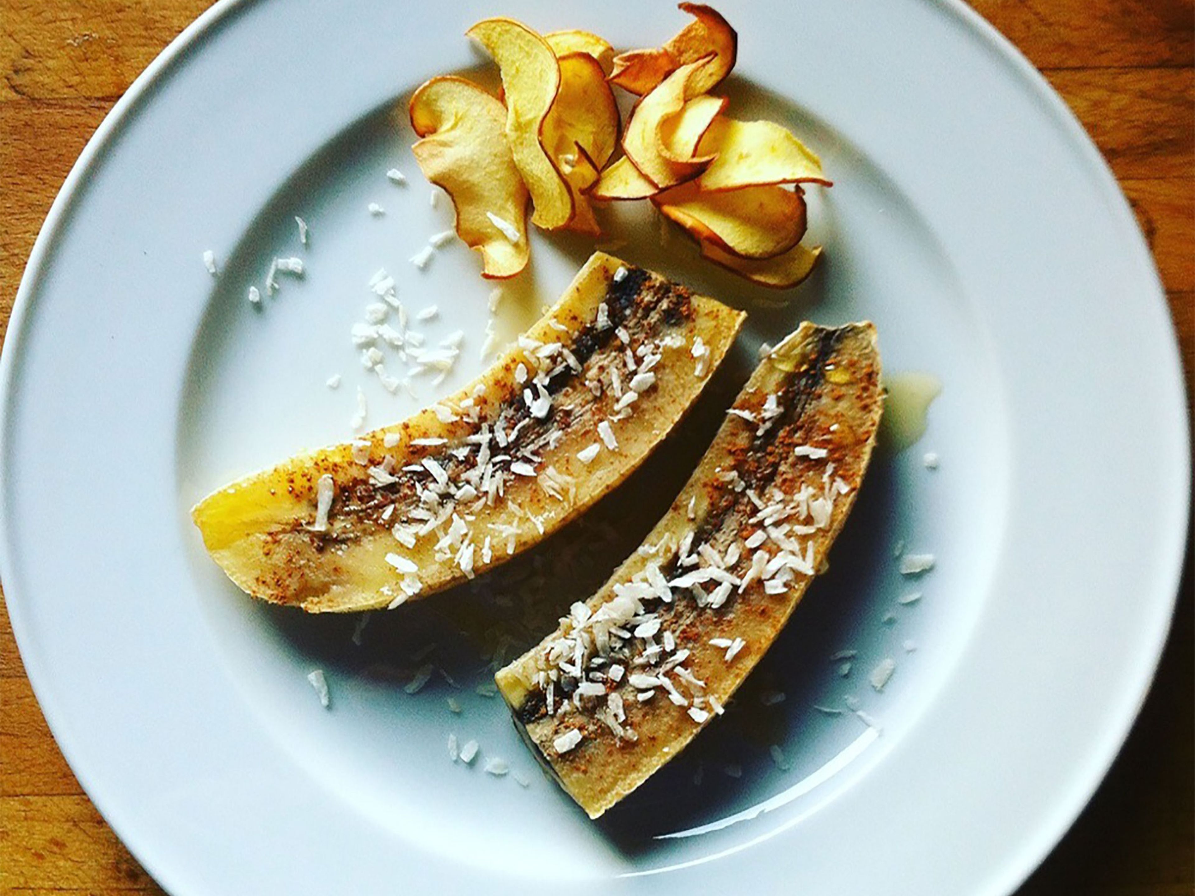 Halve the bananas, transfer to plates together with apple chips. Sprinkle with coconut flakes and pour agave syrup over bananas. Enjoy!