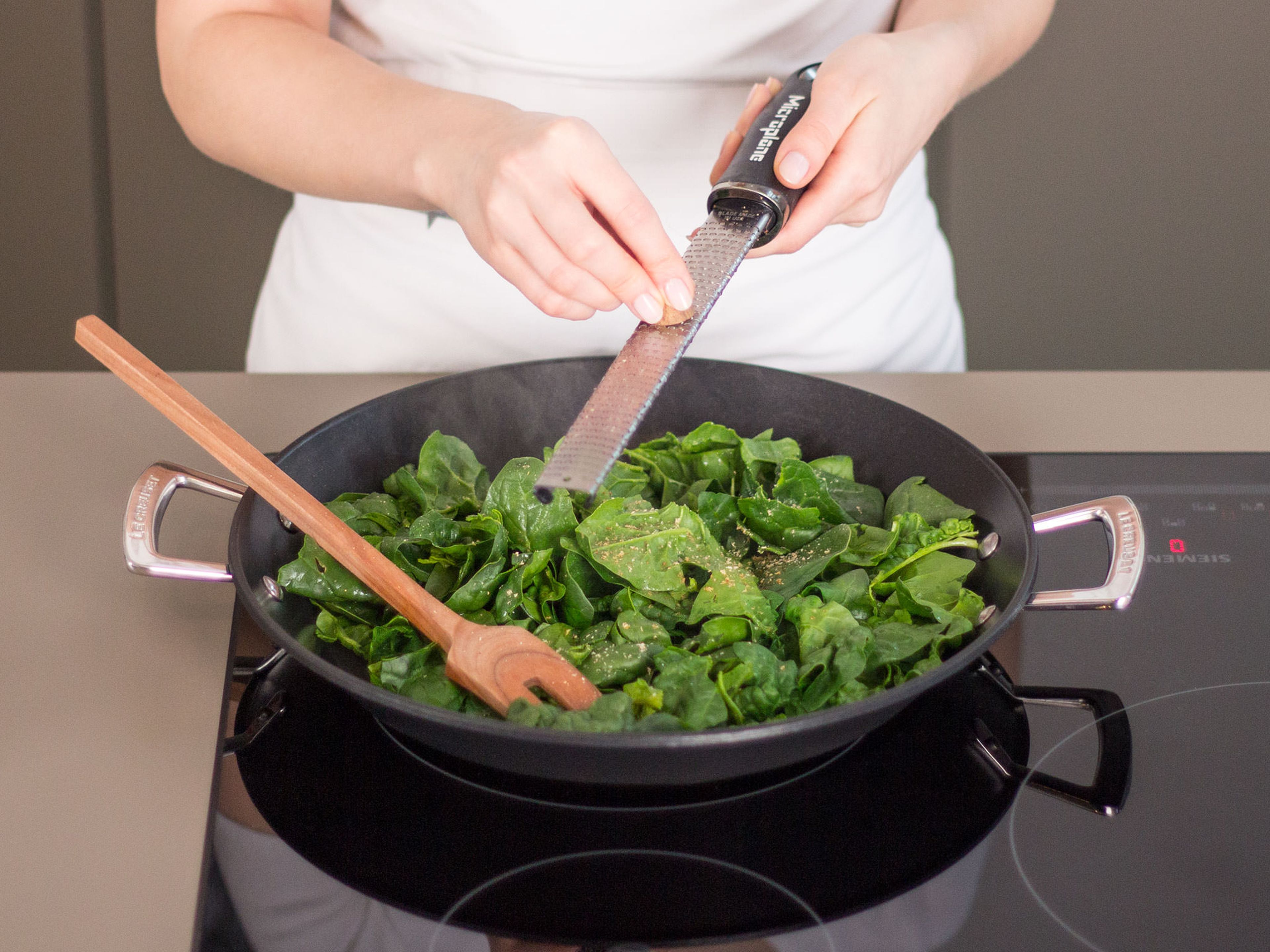 In a frying pan, sauté the spinach until wilted. Season to taste with nutmeg, salt, and pepper. Set aside.